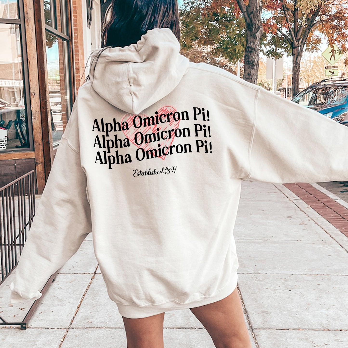 a woman in a white hoodie is walking down the street