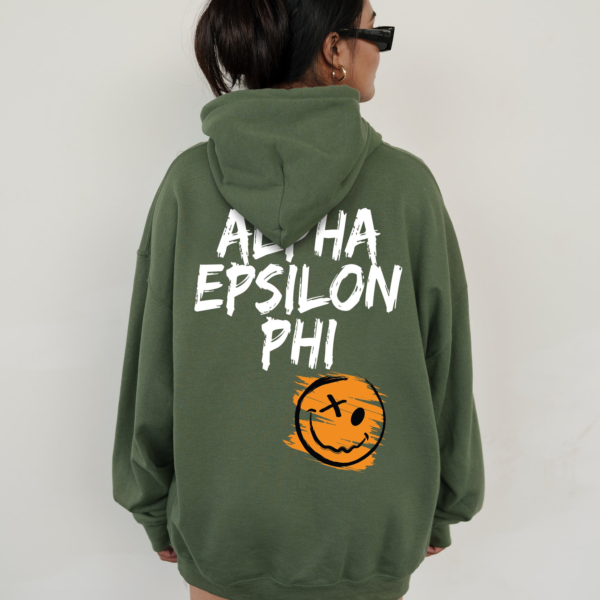 a woman wearing a green sweatshirt with a smiley face on it