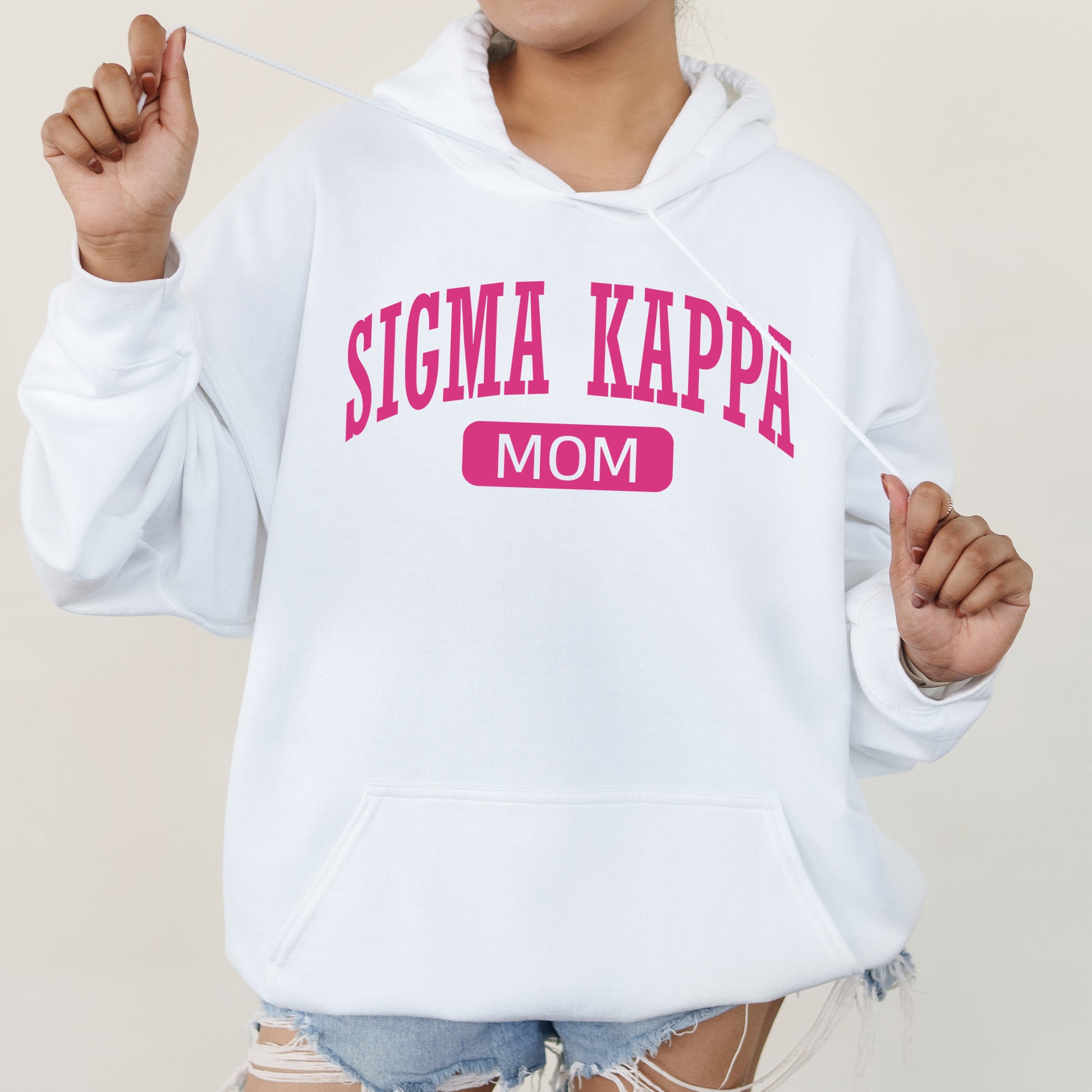 a woman wearing a white sweatshirt that says stigmaa kappe mom
