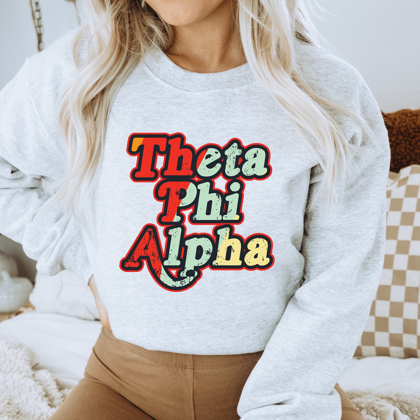 a woman wearing a sweatshirt that says thea phi ah