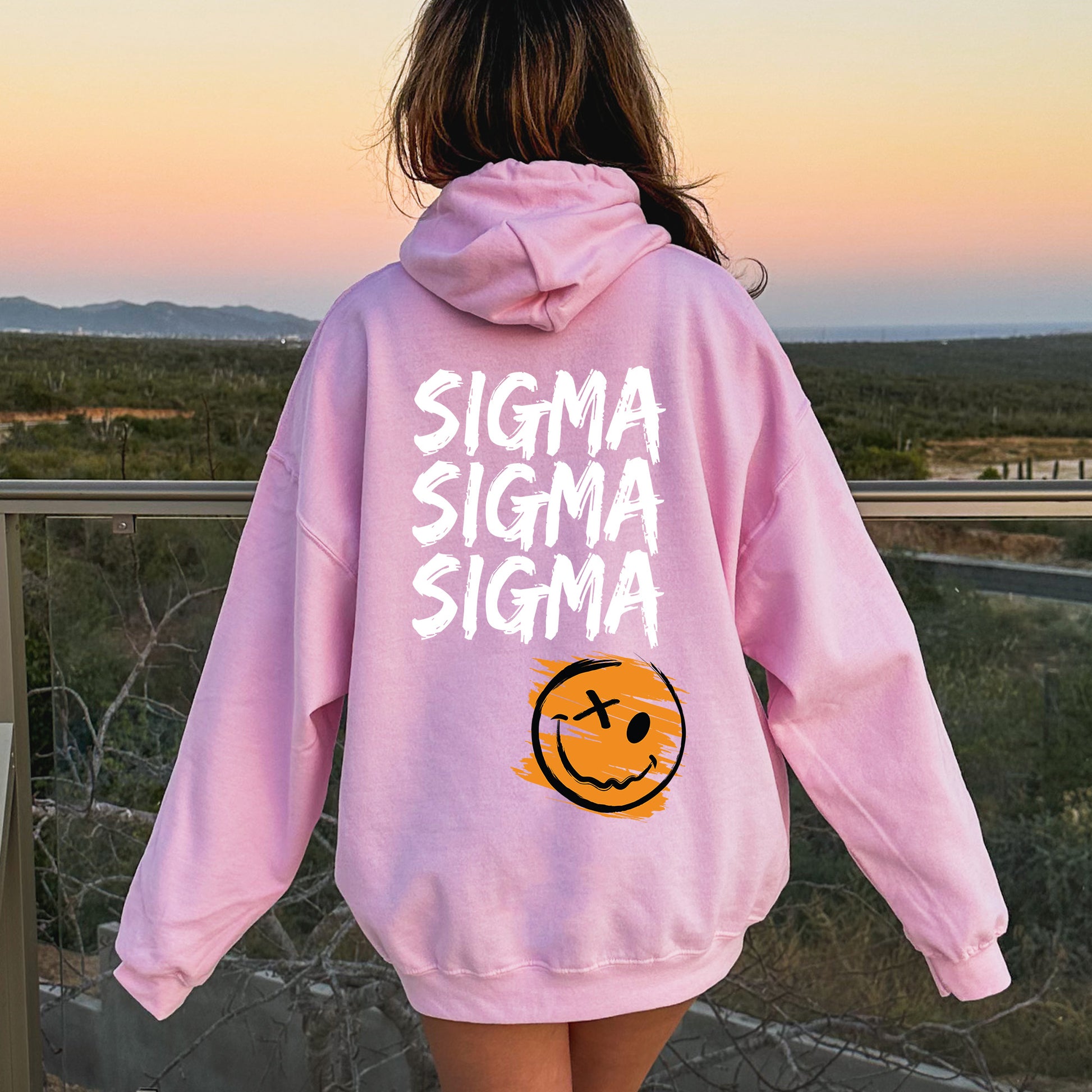 a girl wearing a pink sweatshirt with a smiley face on it