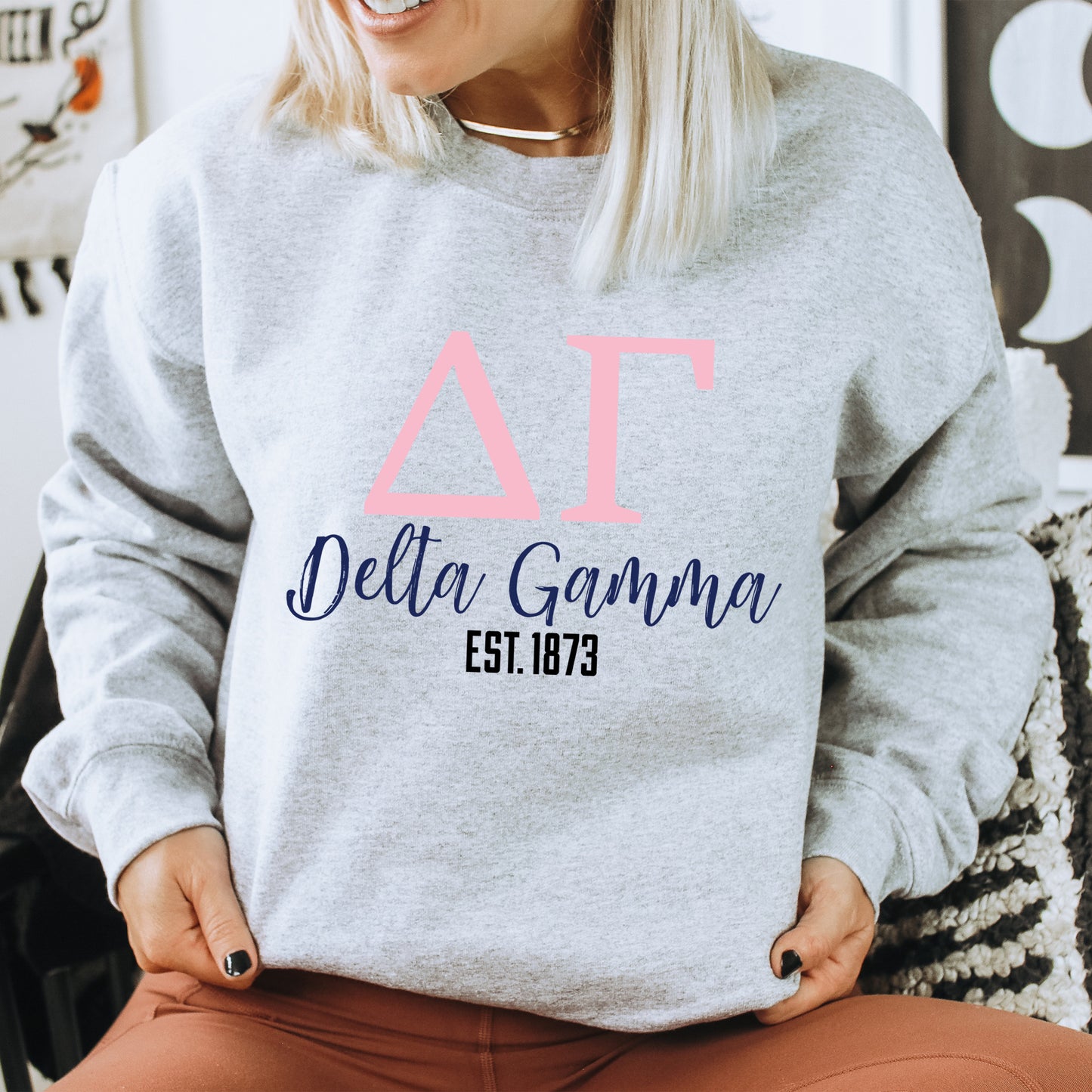 a woman sitting on a chair wearing a sweatshirt