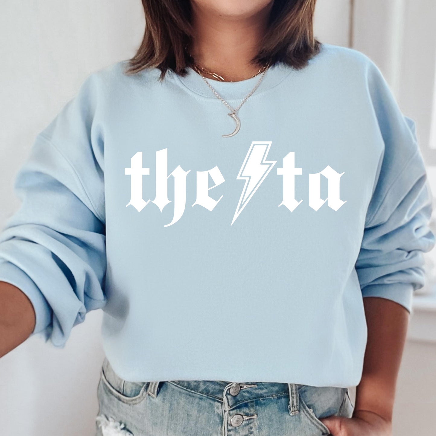 a woman wearing a blue sweatshirt with the word the tata printed on it