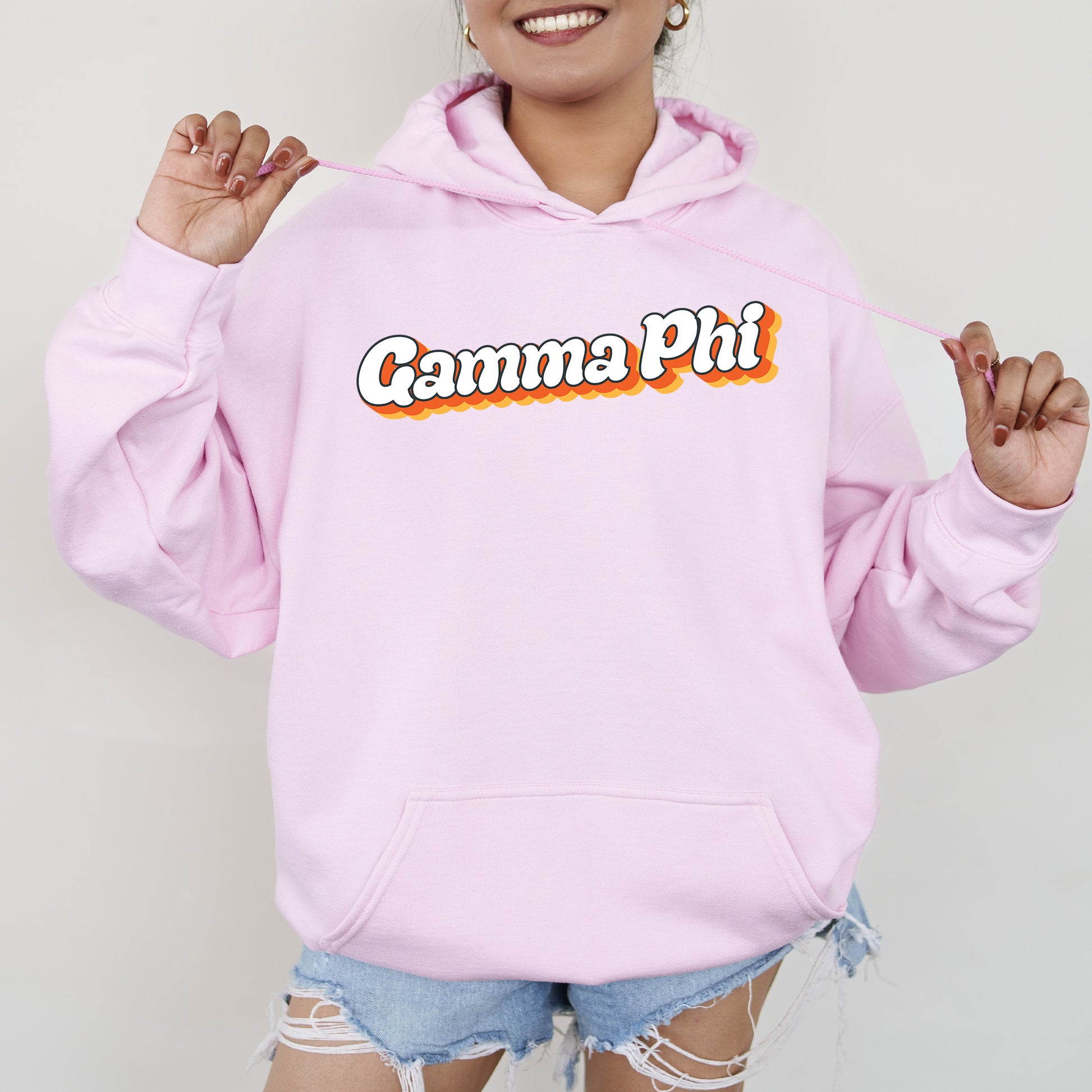 a woman wearing a pink hoodie with the word camera on it