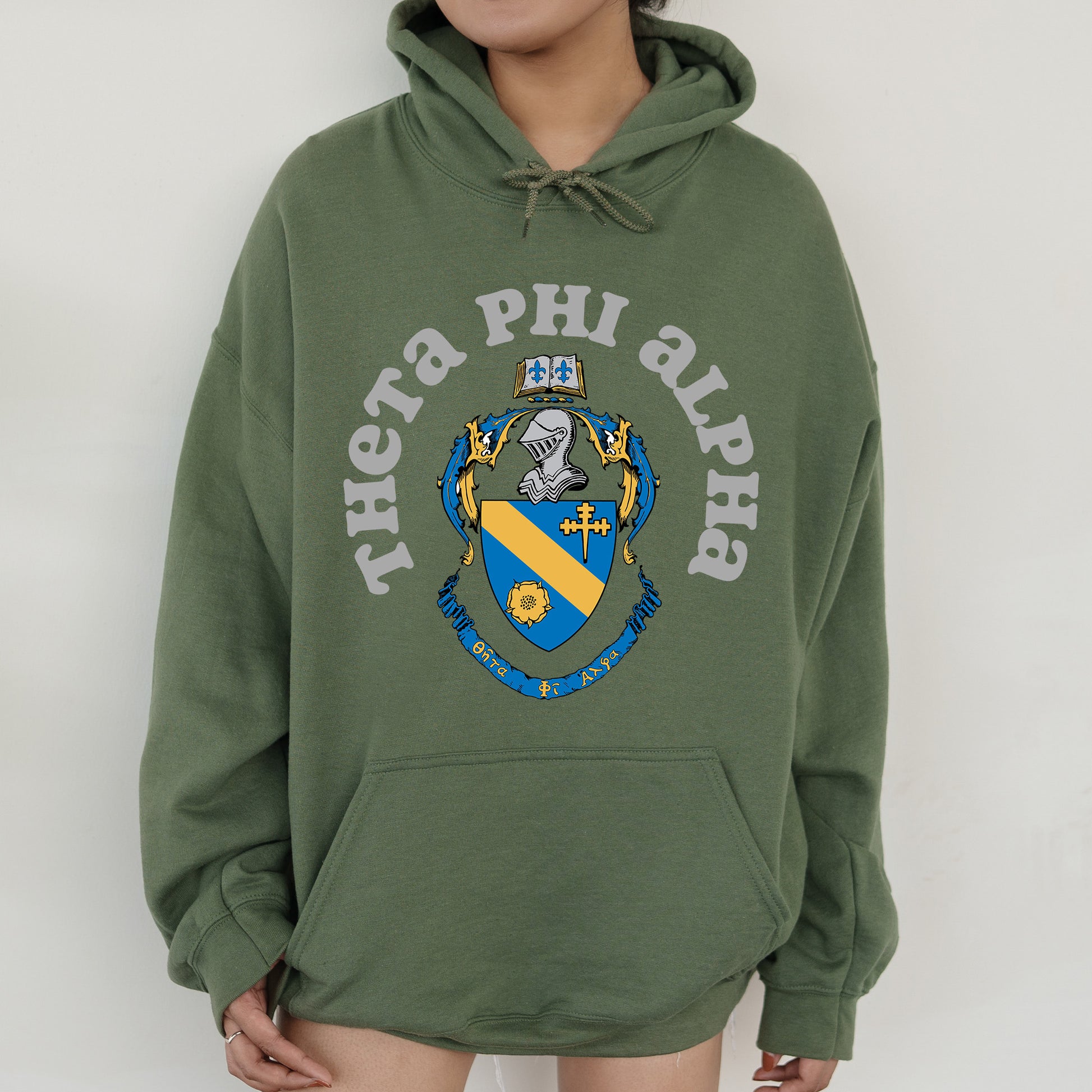 a person wearing a green hoodie with a coat of arms on it