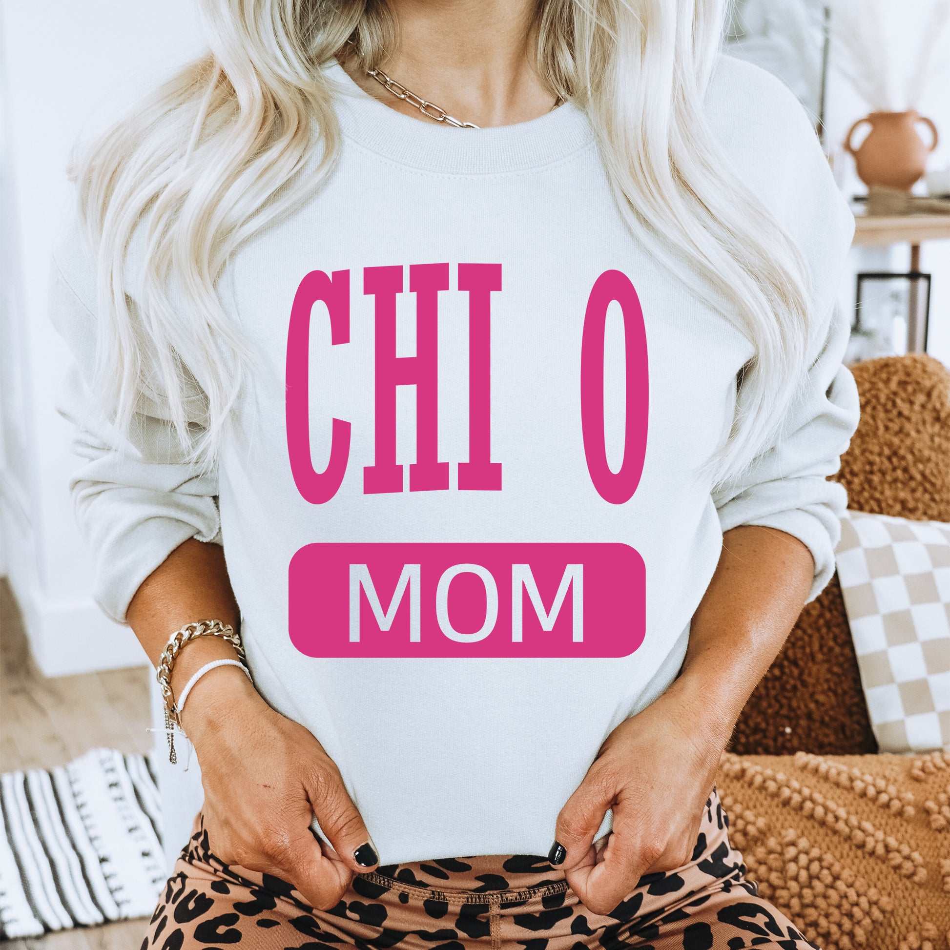 a woman wearing a sweatshirt that says chio mom