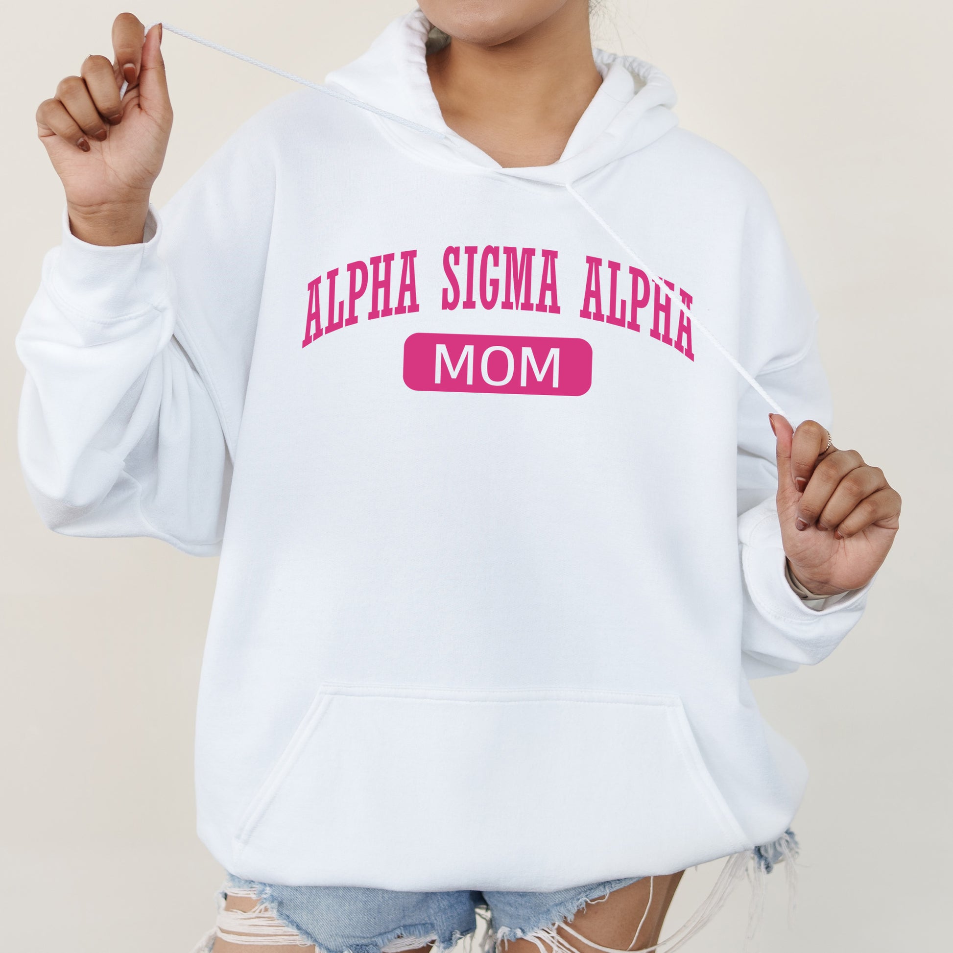 a woman wearing a white hoodie with a pink sticker on it