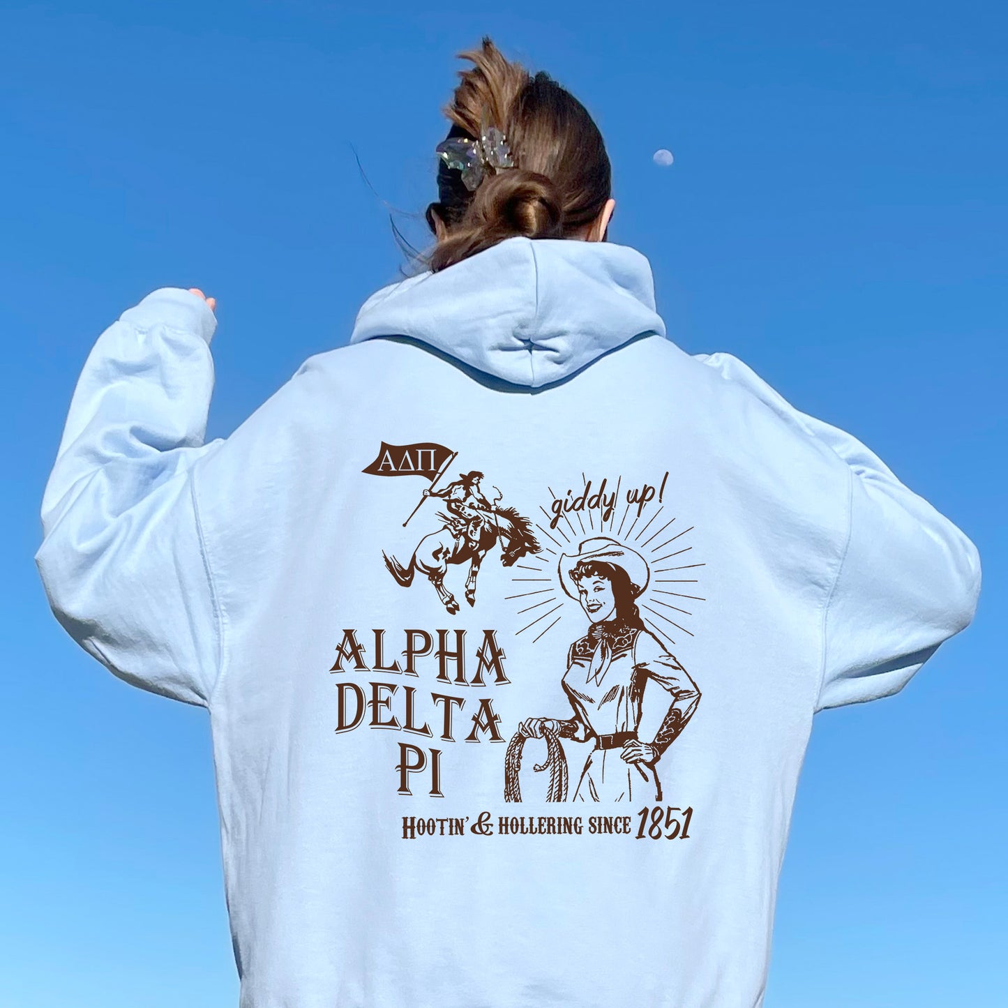 a woman in a white hoodie is flying a kite