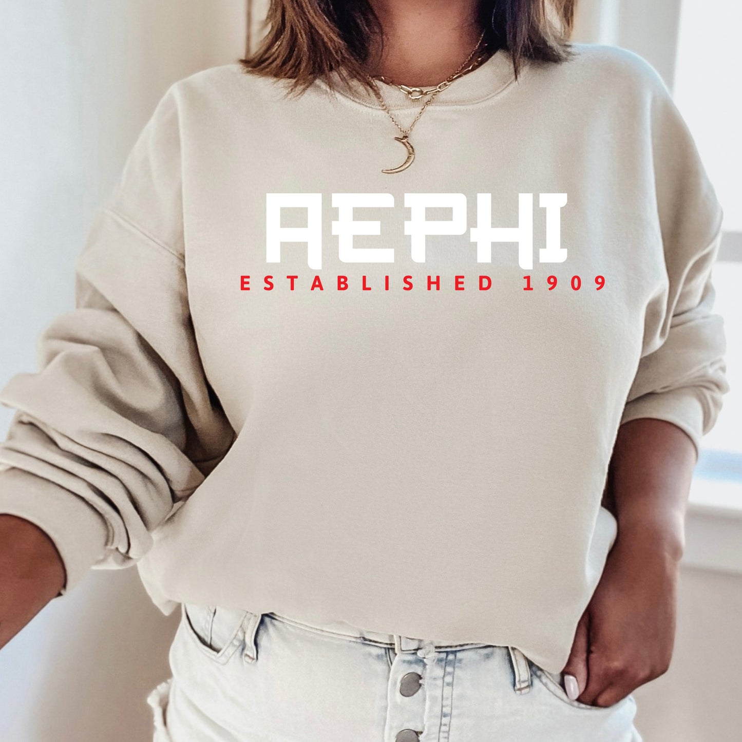 a woman wearing a sweatshirt that reads aeph established 1909