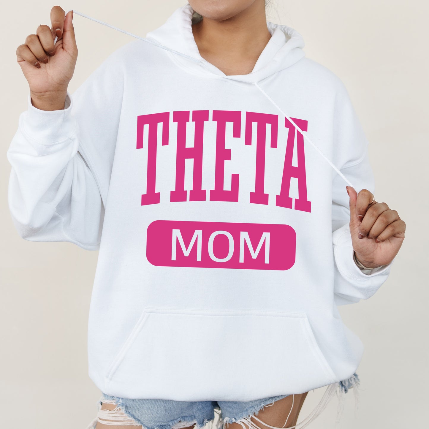 a woman wearing a white sweatshirt with the words theta on it