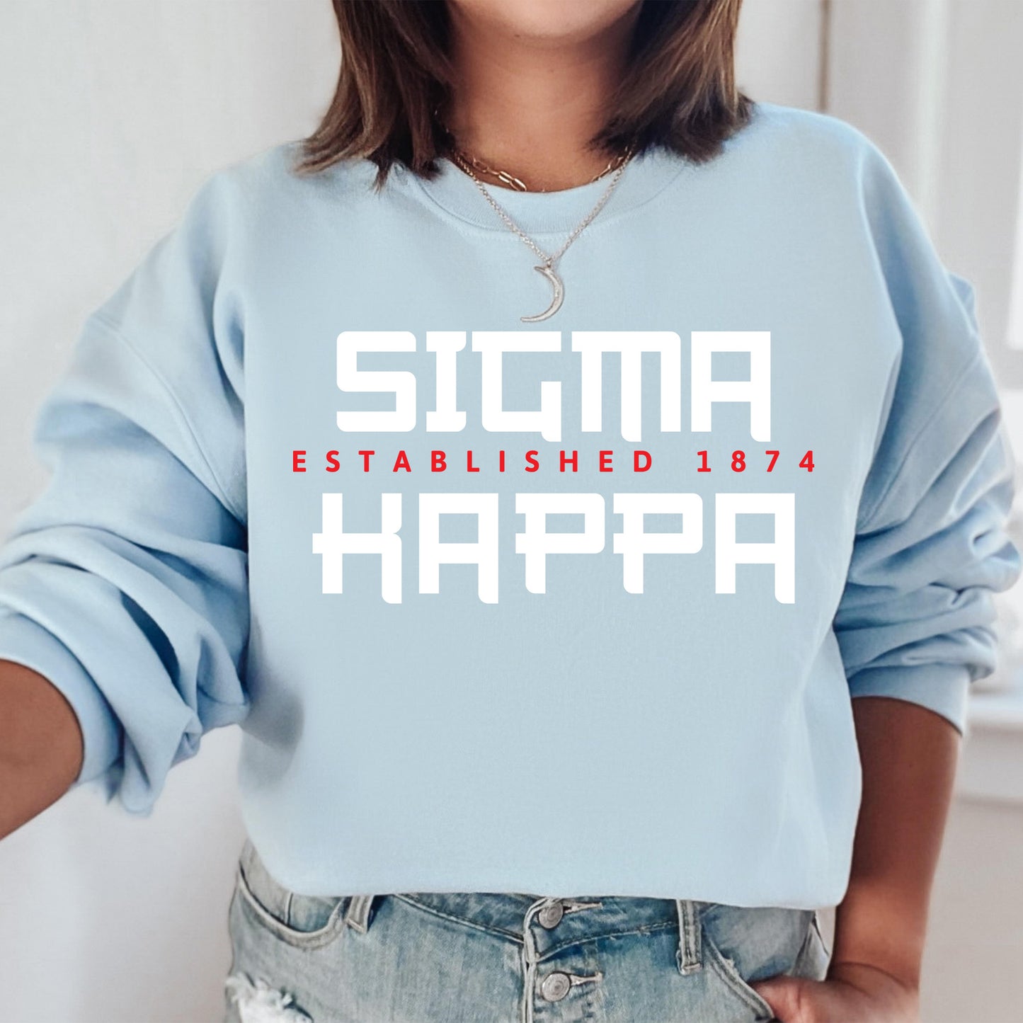 a woman wearing a blue sweatshirt with the words stigmaa established 1974 on it