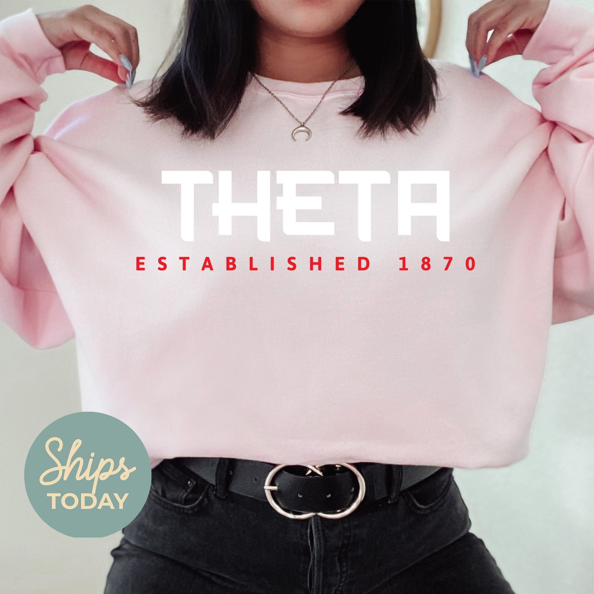 a woman wearing a pink sweatshirt with the words theta on it