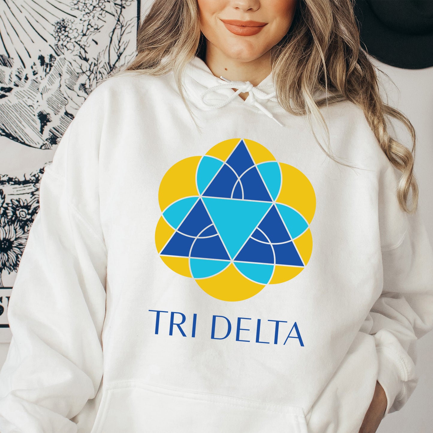 a woman wearing a white hoodie with a tri delta logo on it