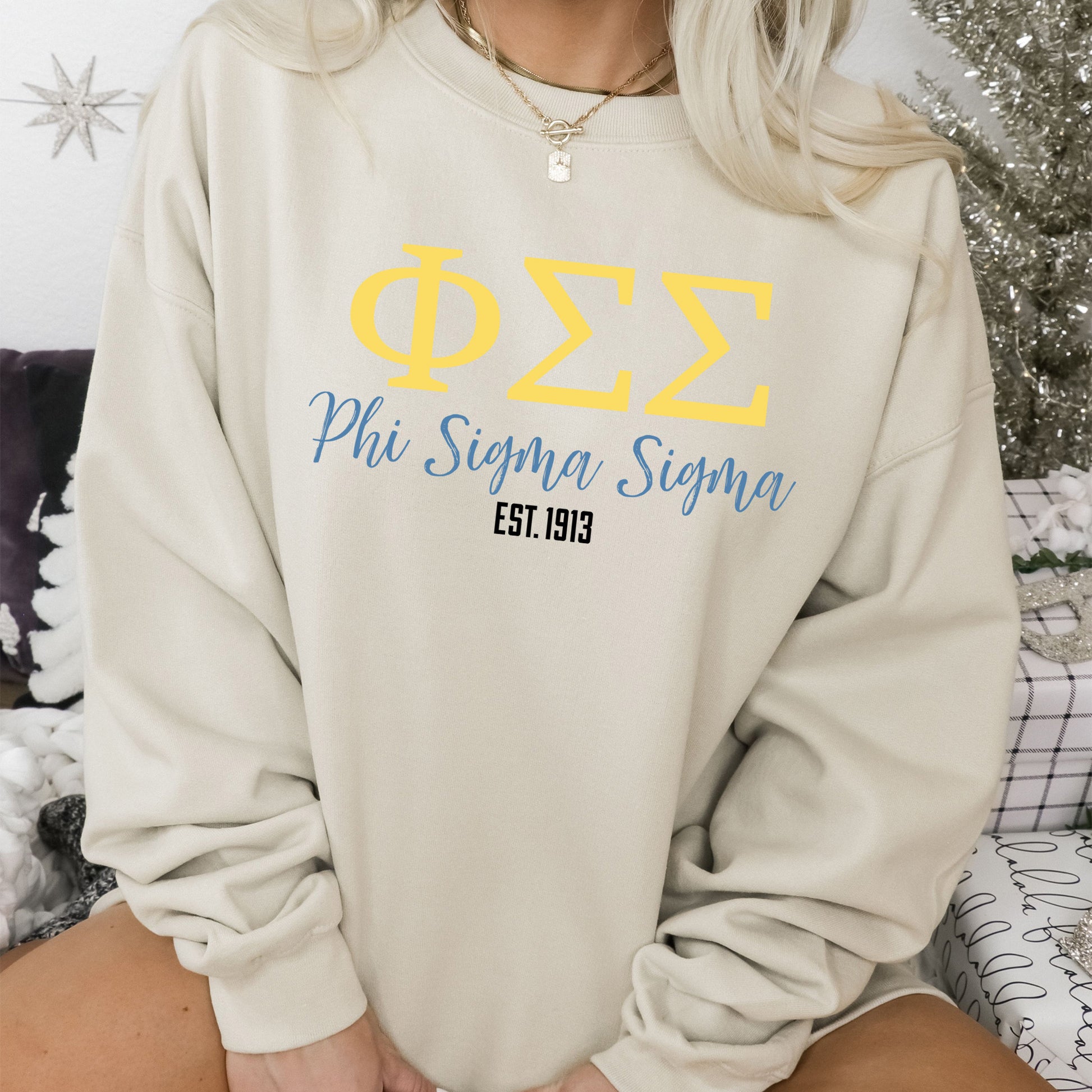 a woman sitting on a bed wearing a sweatshirt