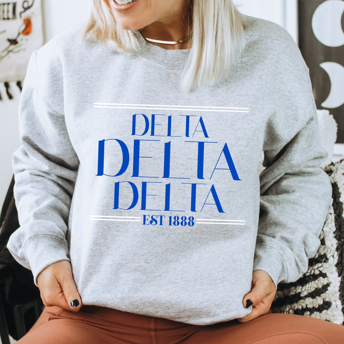 a woman wearing a sweatshirt that says delta delta