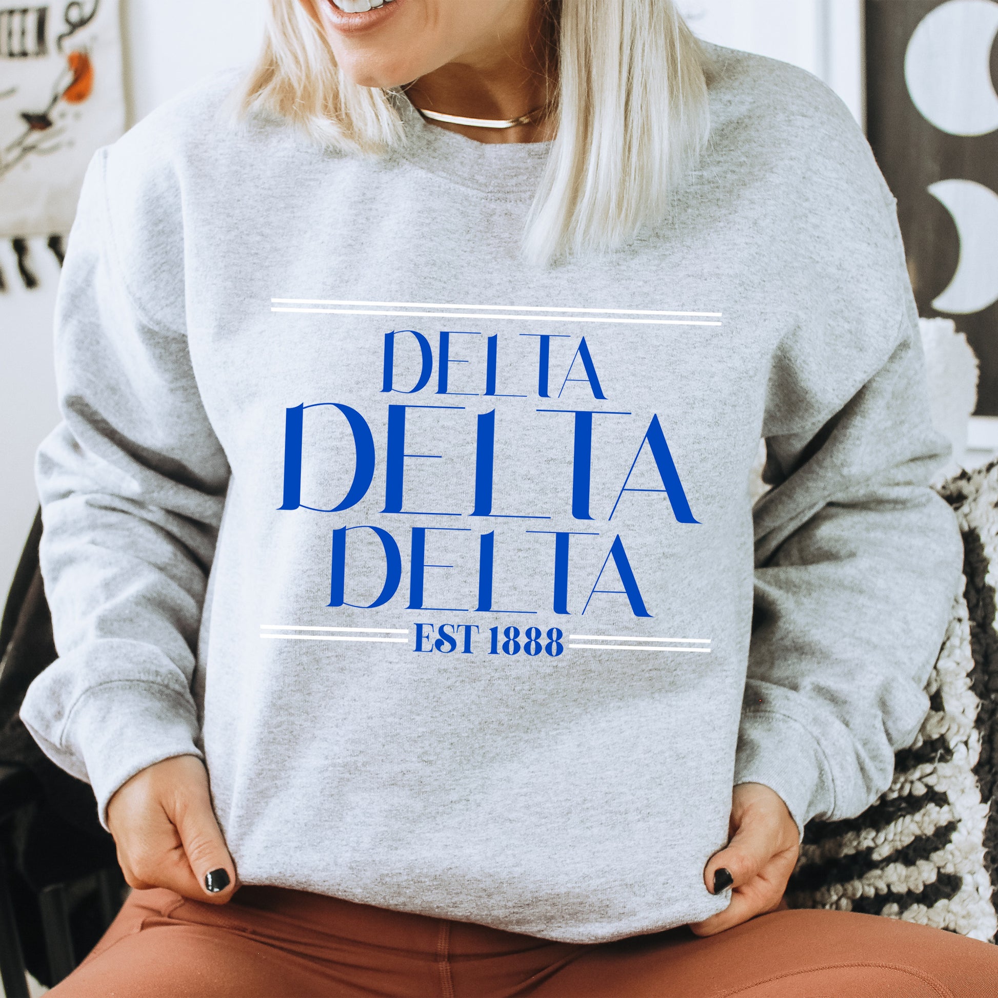 a woman wearing a sweatshirt that says delta delta
