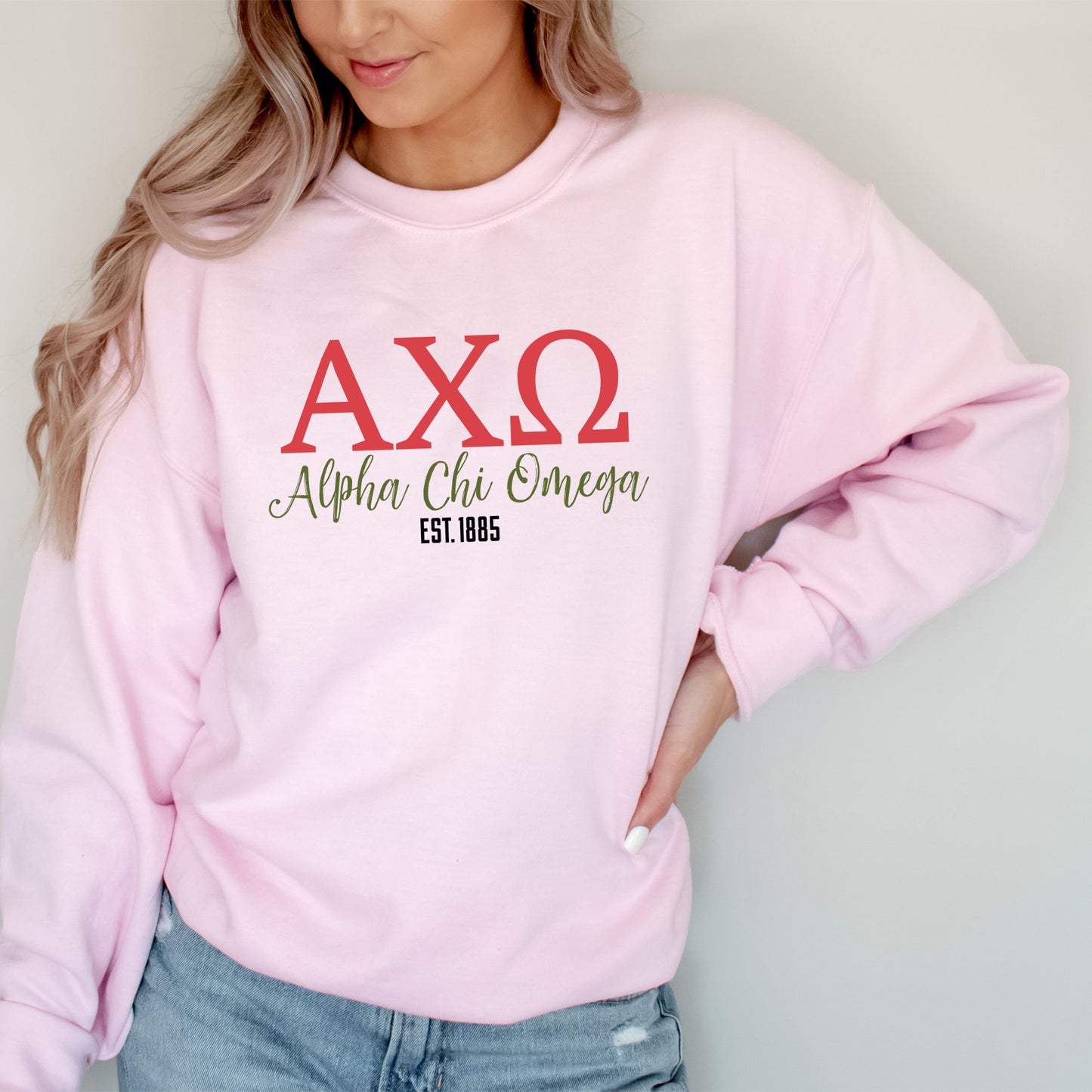 a woman wearing a pink sweatshirt and jeans