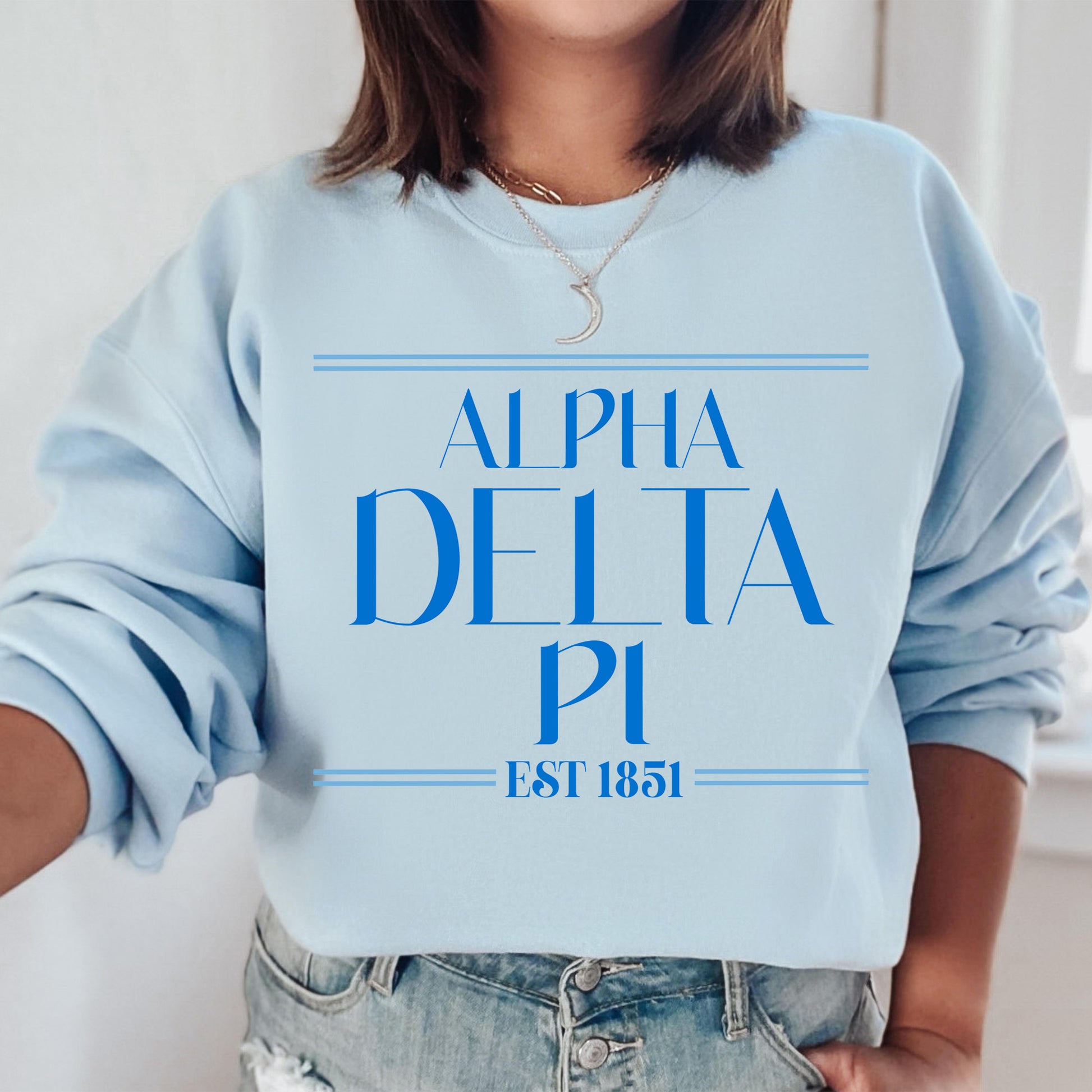 a woman wearing a blue sweatshirt with the word delta pi printed on it