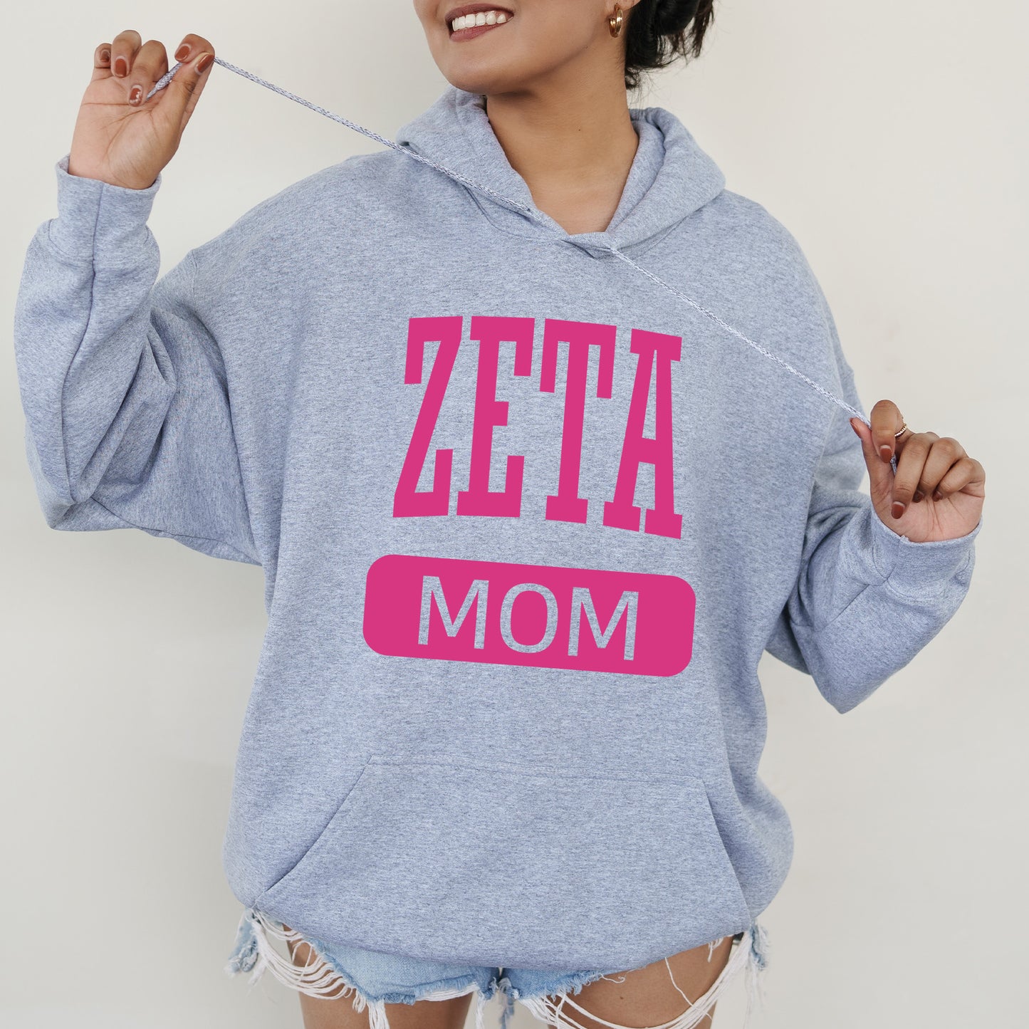 a woman wearing a blue sweatshirt with pink letters on it