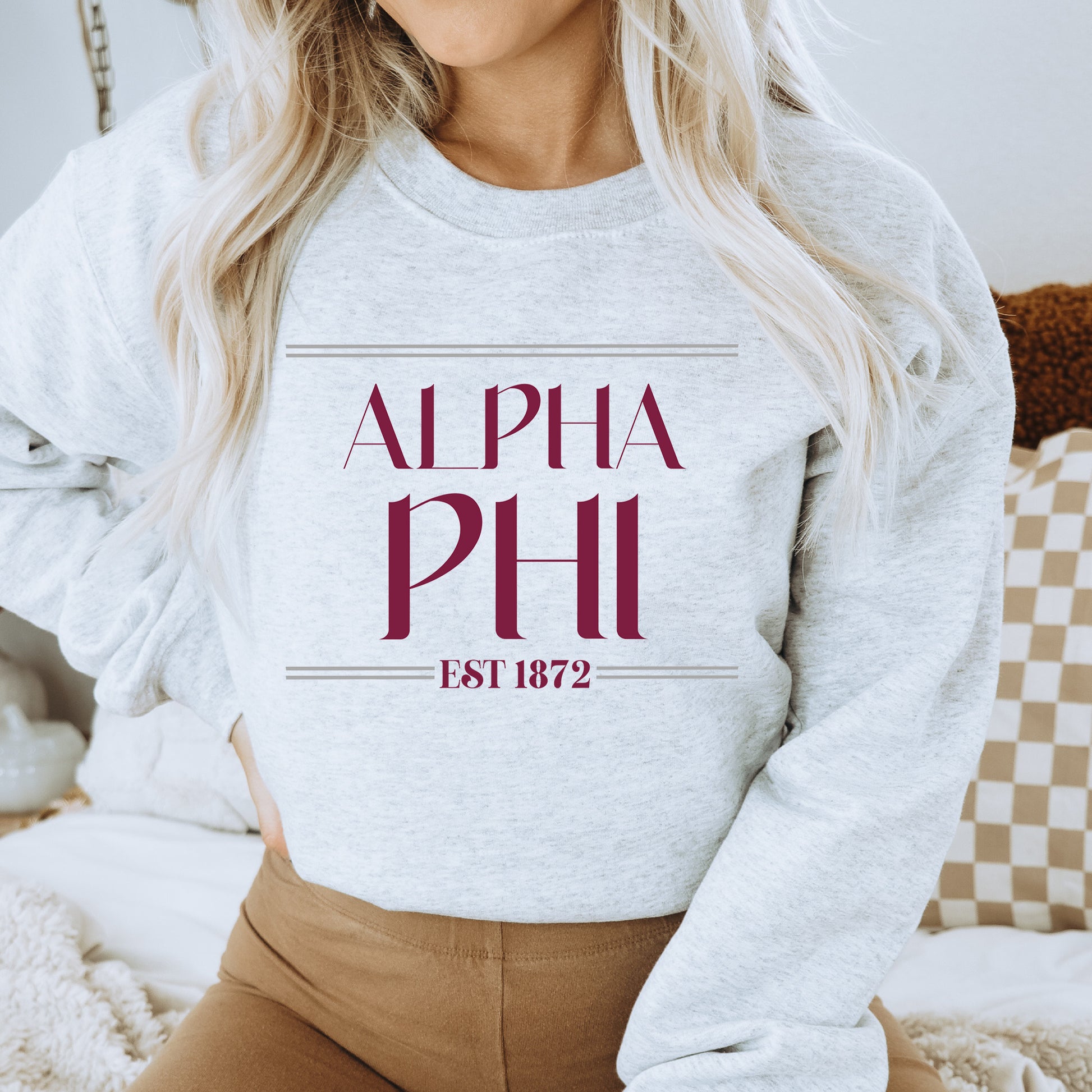 a woman wearing a sweatshirt that says,'alpha phi est 1897 '