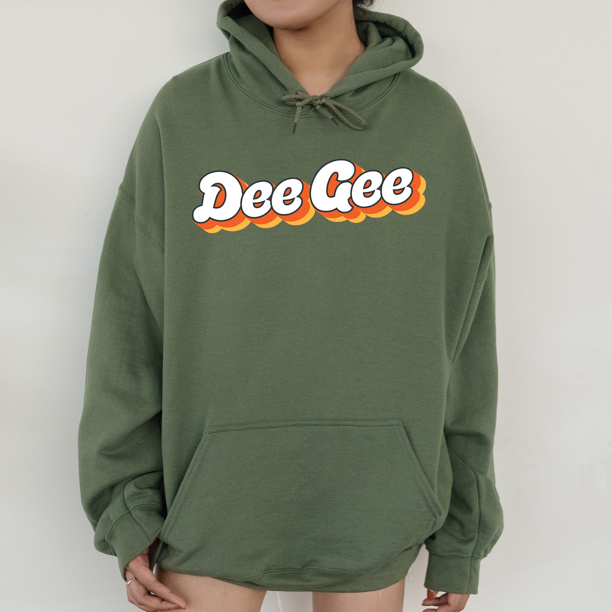 a woman wearing a green sweatshirt with the word dee gee on it
