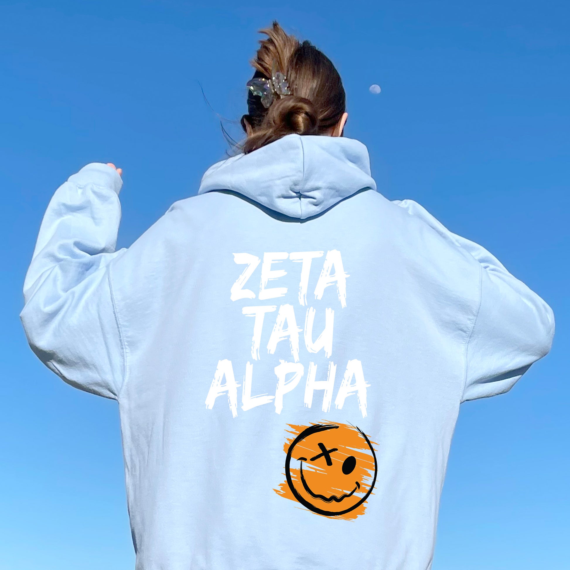 a woman wearing a sweatshirt with a smiley face on it