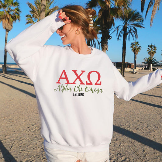 a woman standing on a beach wearing a white sweatshirt