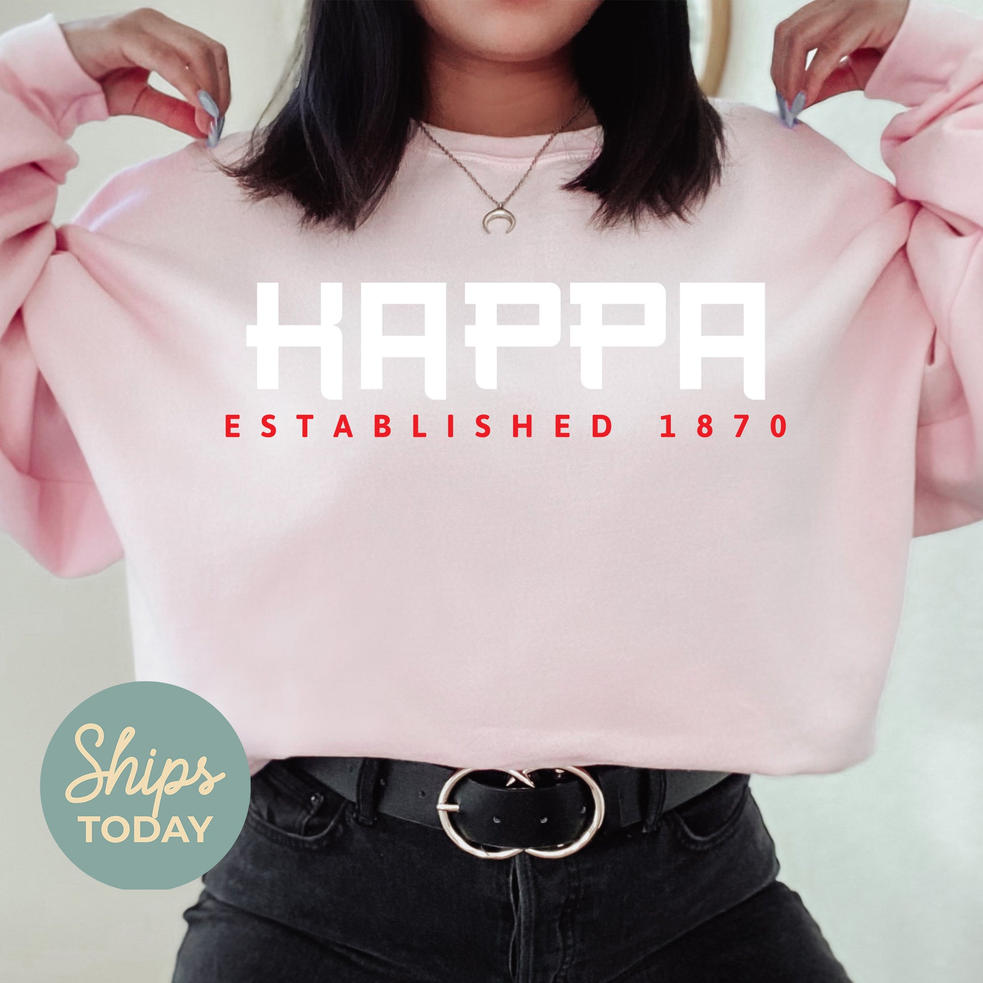 a woman wearing a pink sweatshirt with the words happy established on it