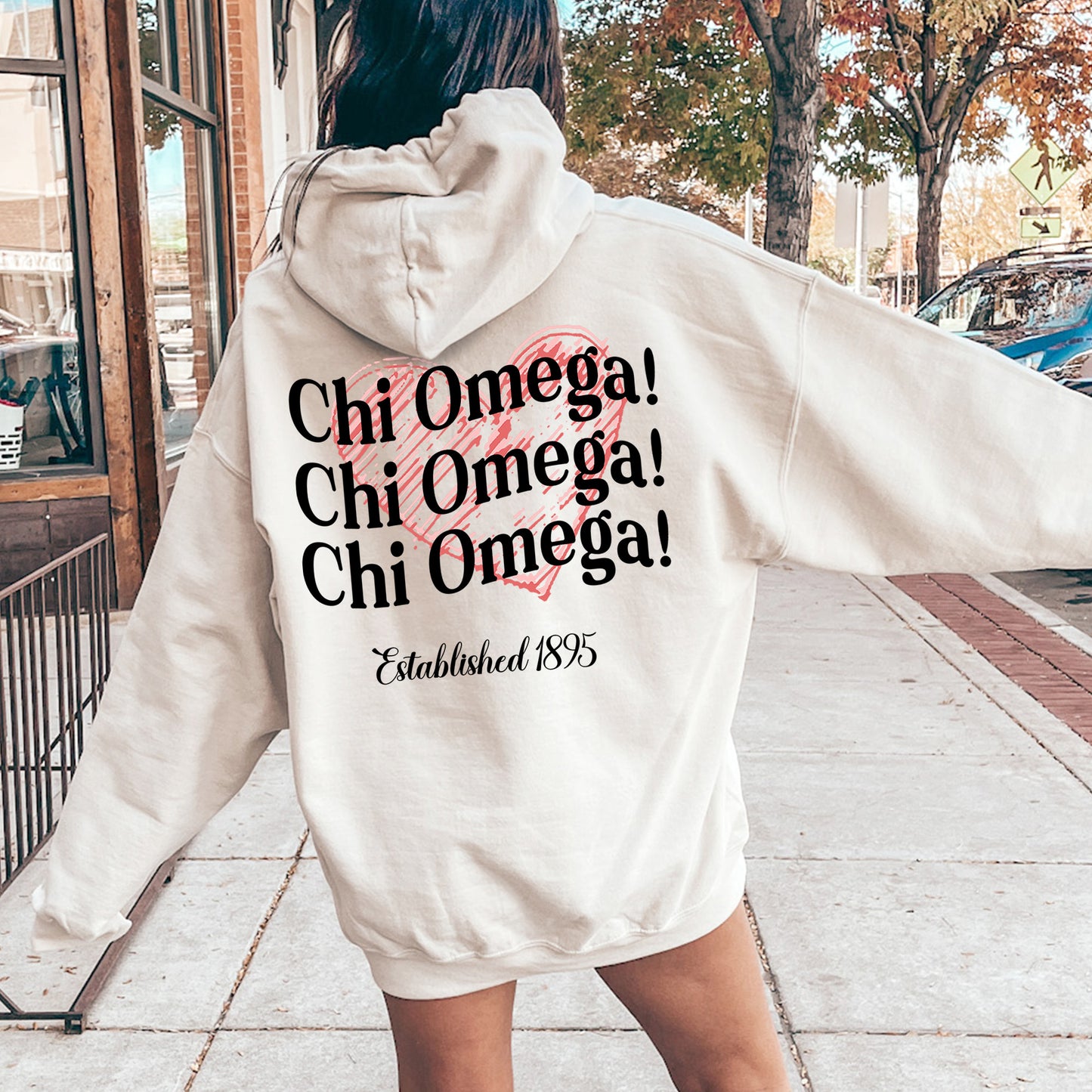 a woman in a white hoodie is walking down the street