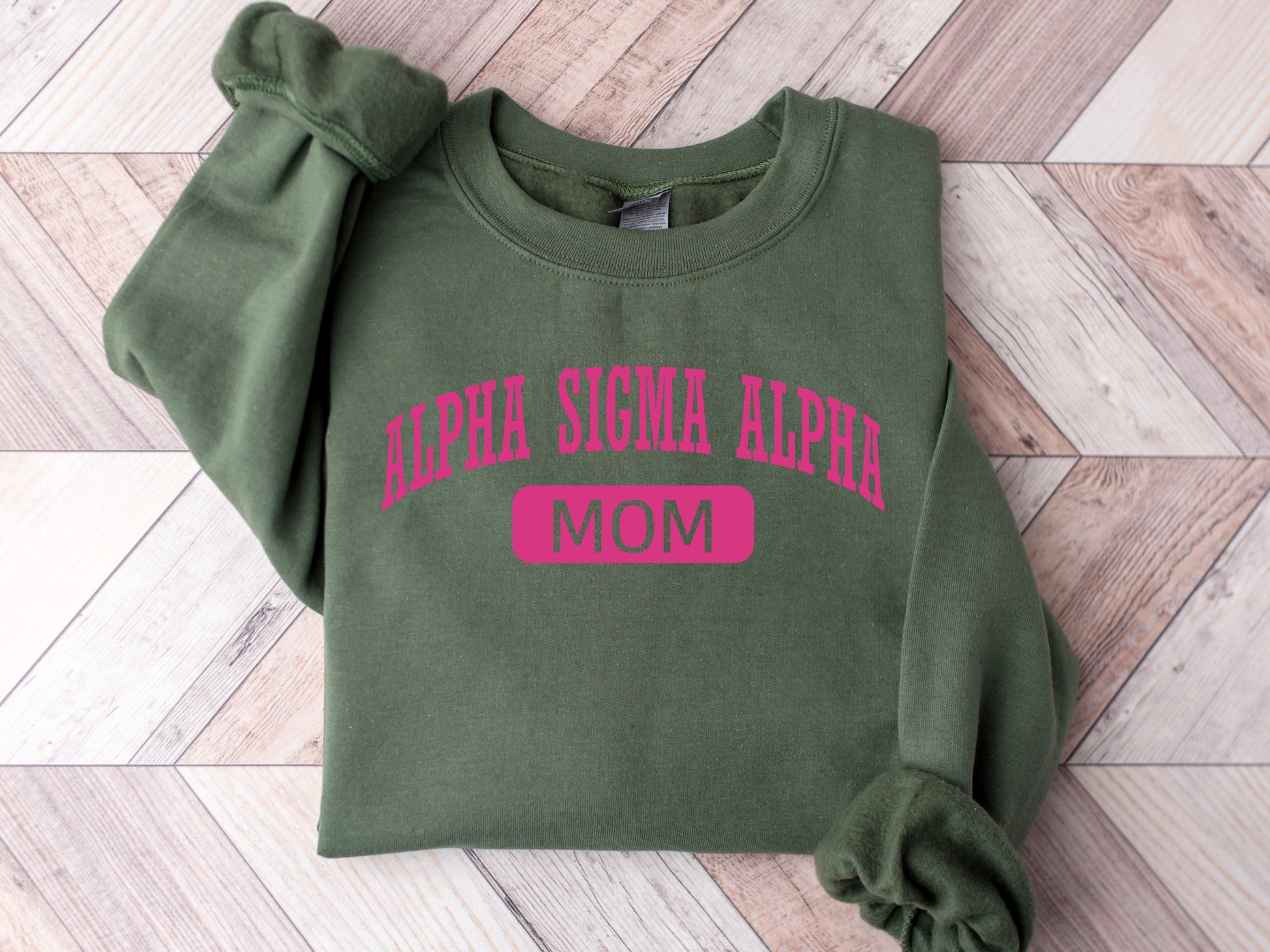 a green sweatshirt with pink letters on it