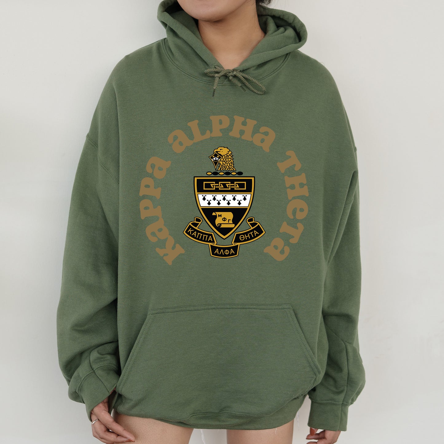 a person wearing a green hoodie with a yellow and black logo on it