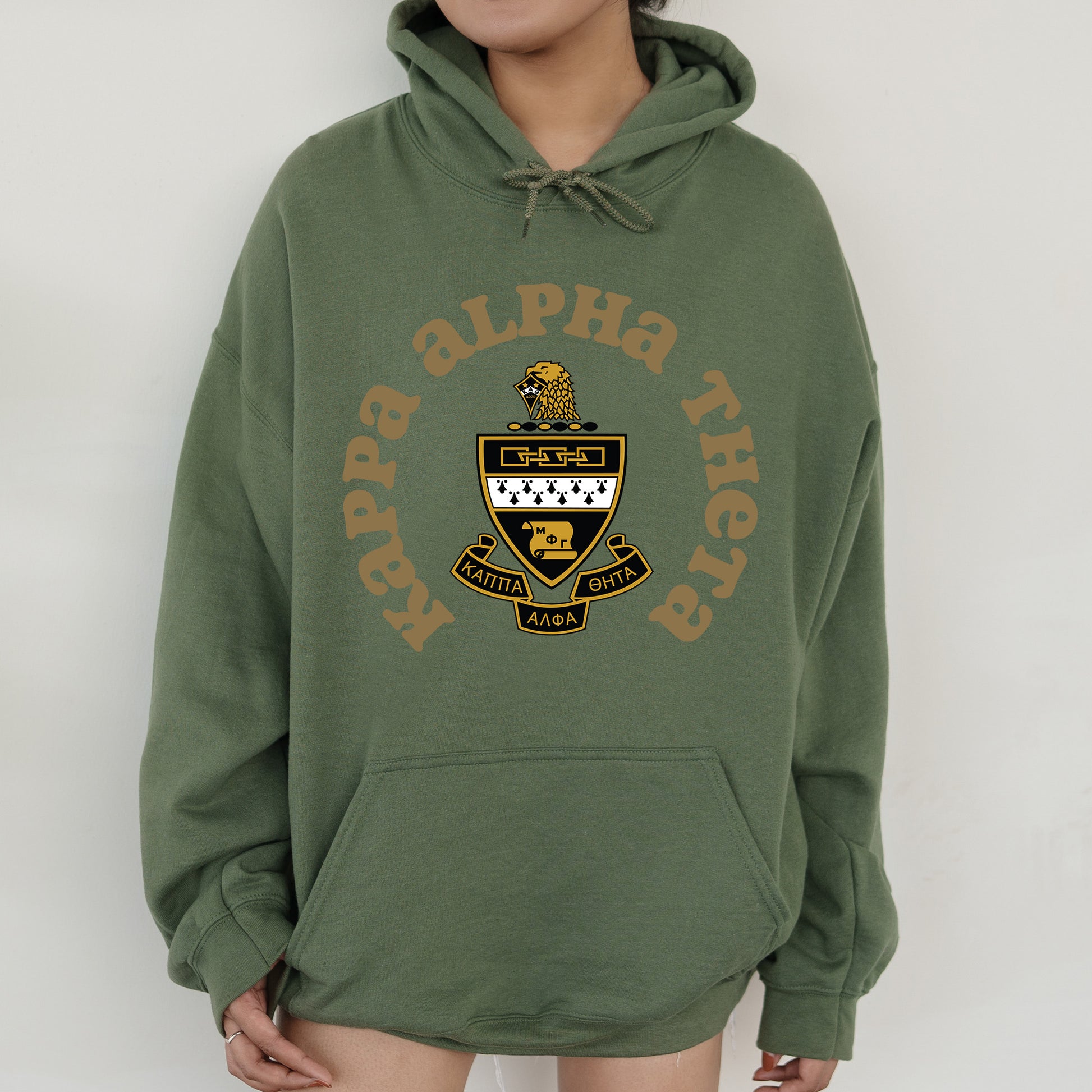 a person wearing a green hoodie with a yellow and black logo on it