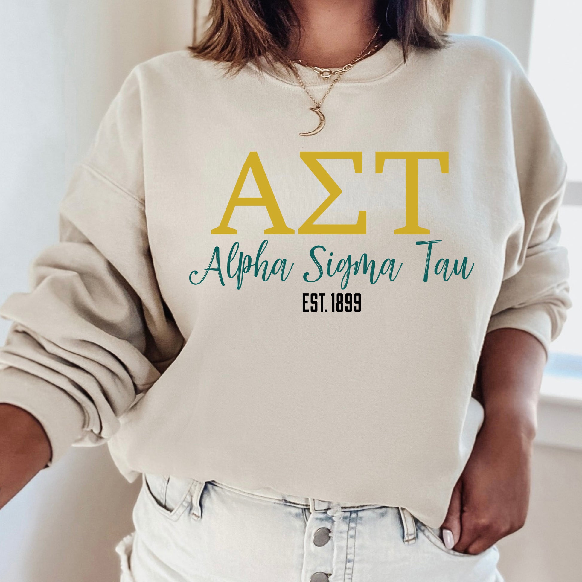 a woman wearing a white sweatshirt with the letters azt on it
