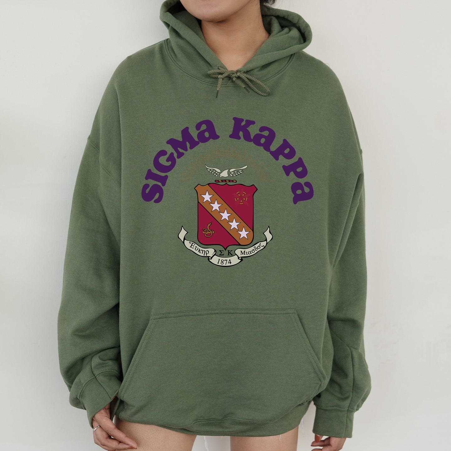 a person wearing a green hoodie with a crest on it
