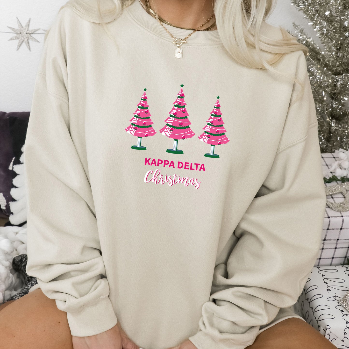 a woman wearing a sweatshirt with christmas trees on it