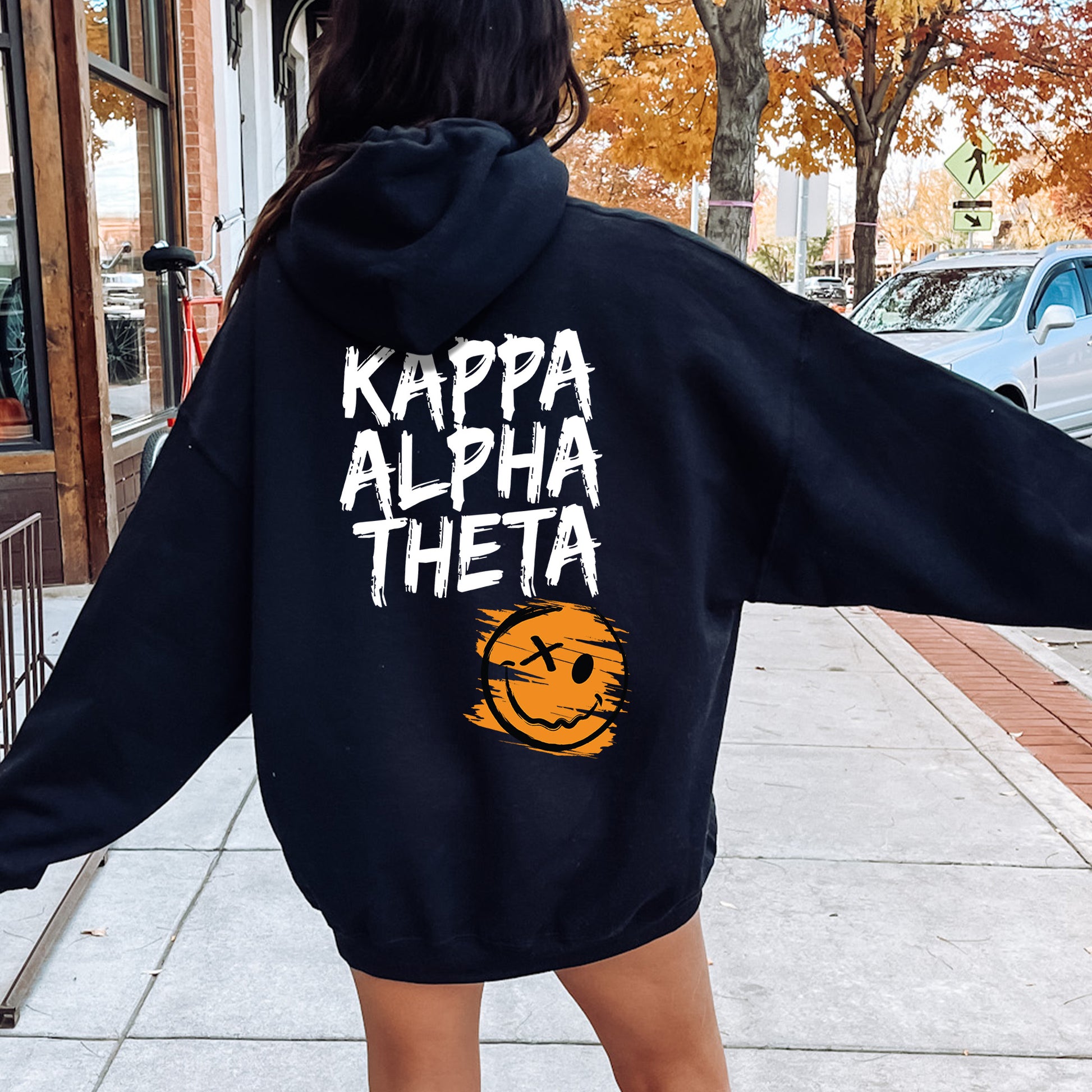 a woman is walking down the sidewalk wearing a hoodie