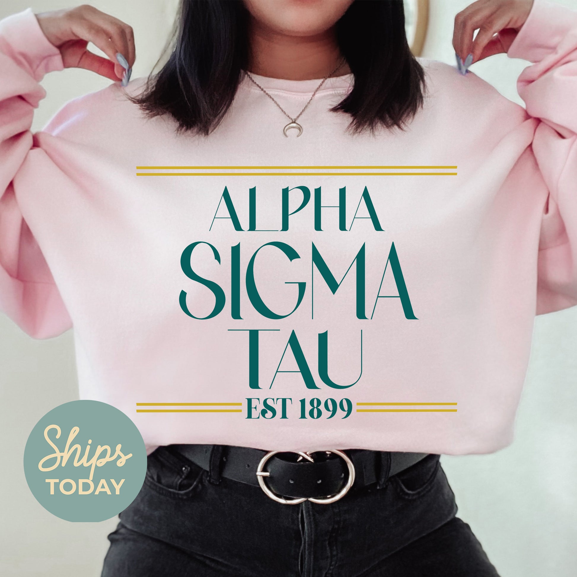 a woman holding up a pink shirt with the words, alpha sigma tau