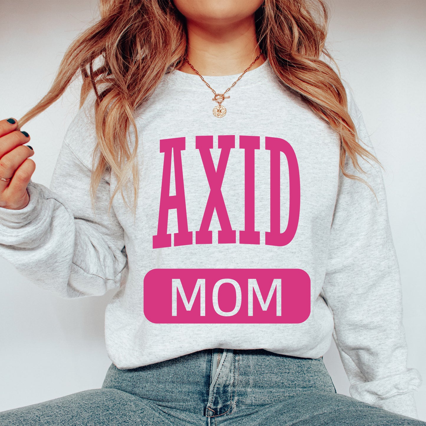 a woman wearing a sweatshirt that says axd mom