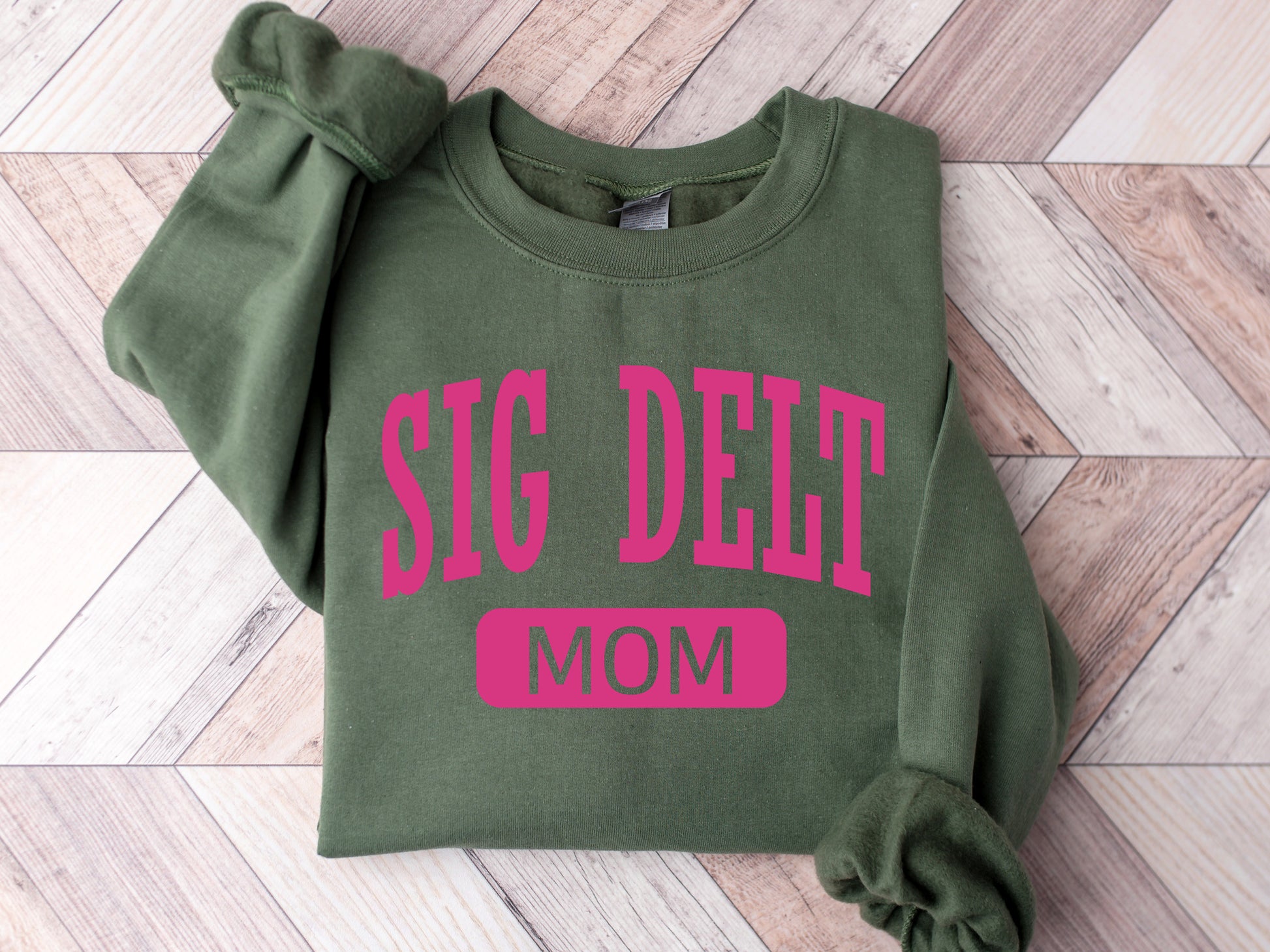 a green sweatshirt with pink lettering that says sig deet mom