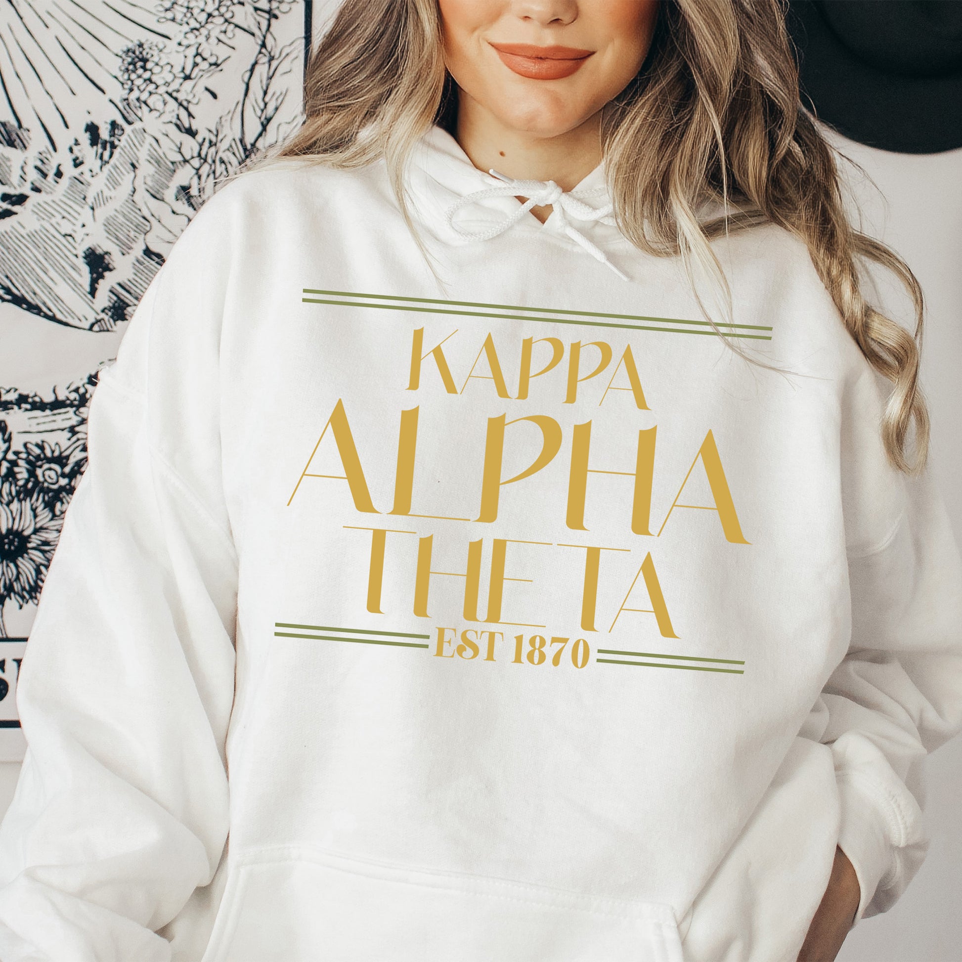a woman wearing a white hoodie with gold lettering