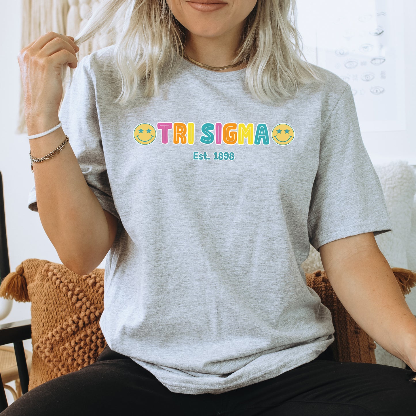 a woman sitting on a chair wearing a grey tshirt