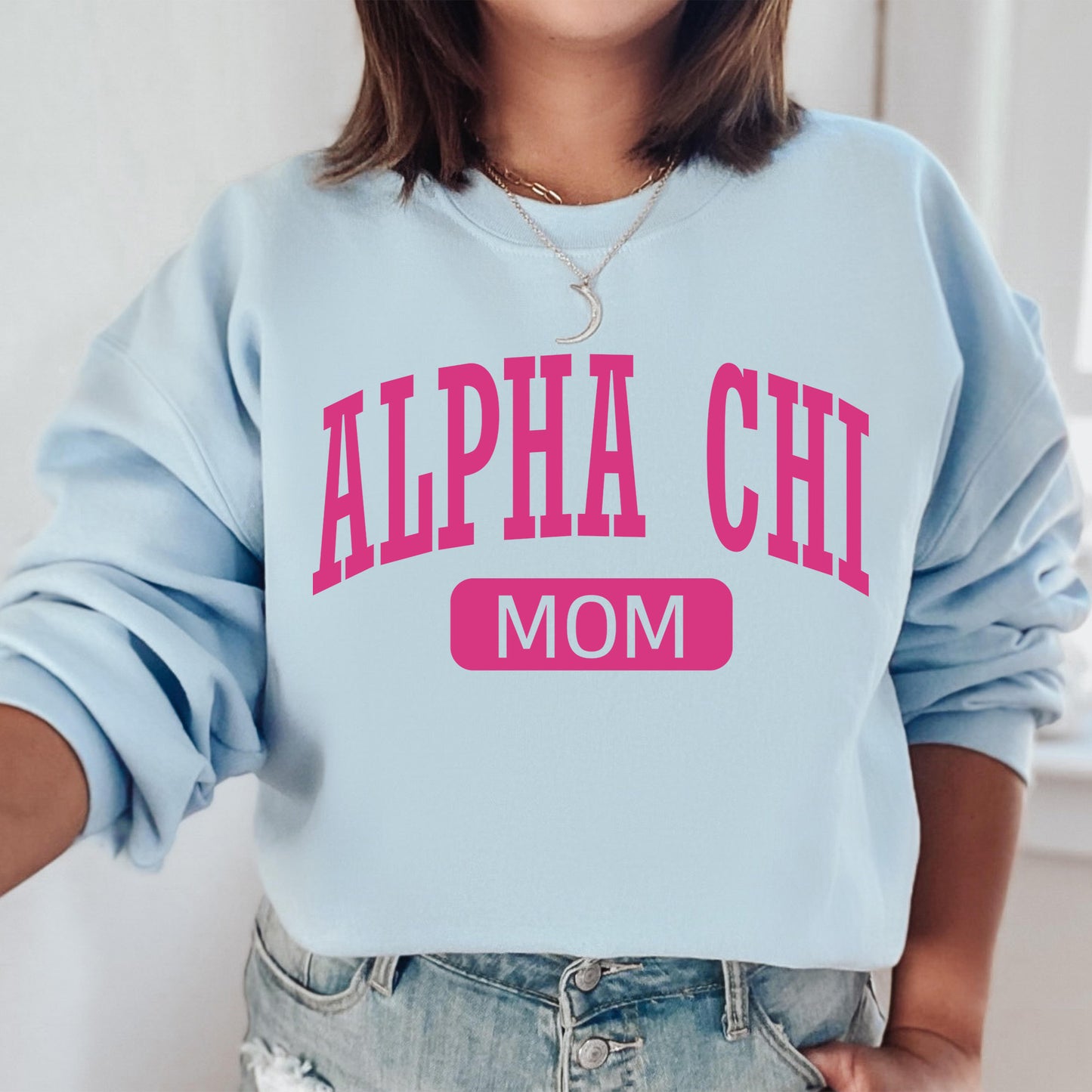 a woman wearing a blue sweatshirt with pink letters on it