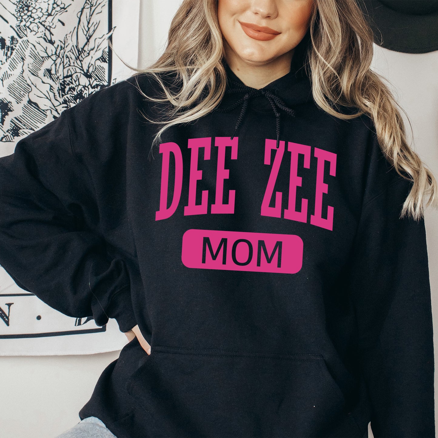 a woman wearing a black hoodie with pink lettering