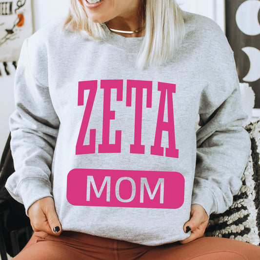 a woman wearing a sweatshirt that says zetta mom