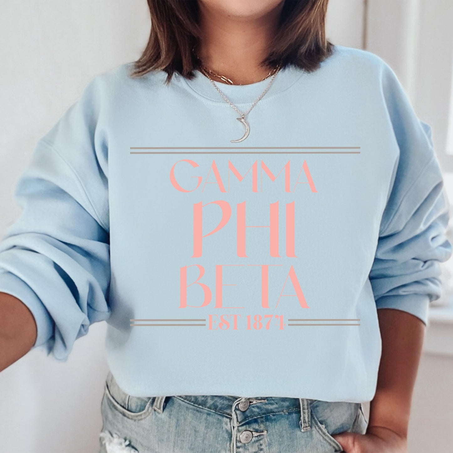 a woman wearing a light blue sweatshirt with pink lettering