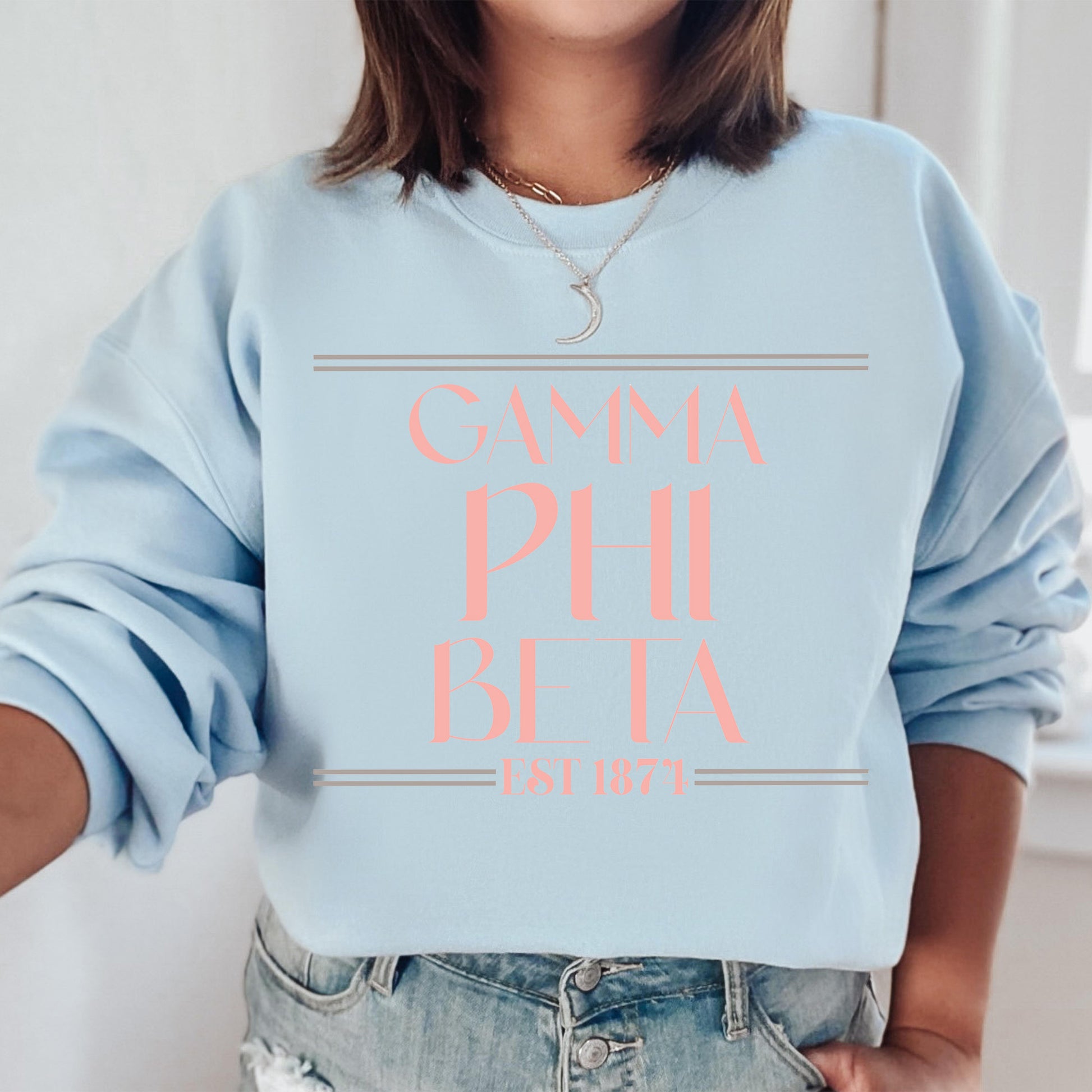 a woman wearing a light blue sweatshirt with pink lettering