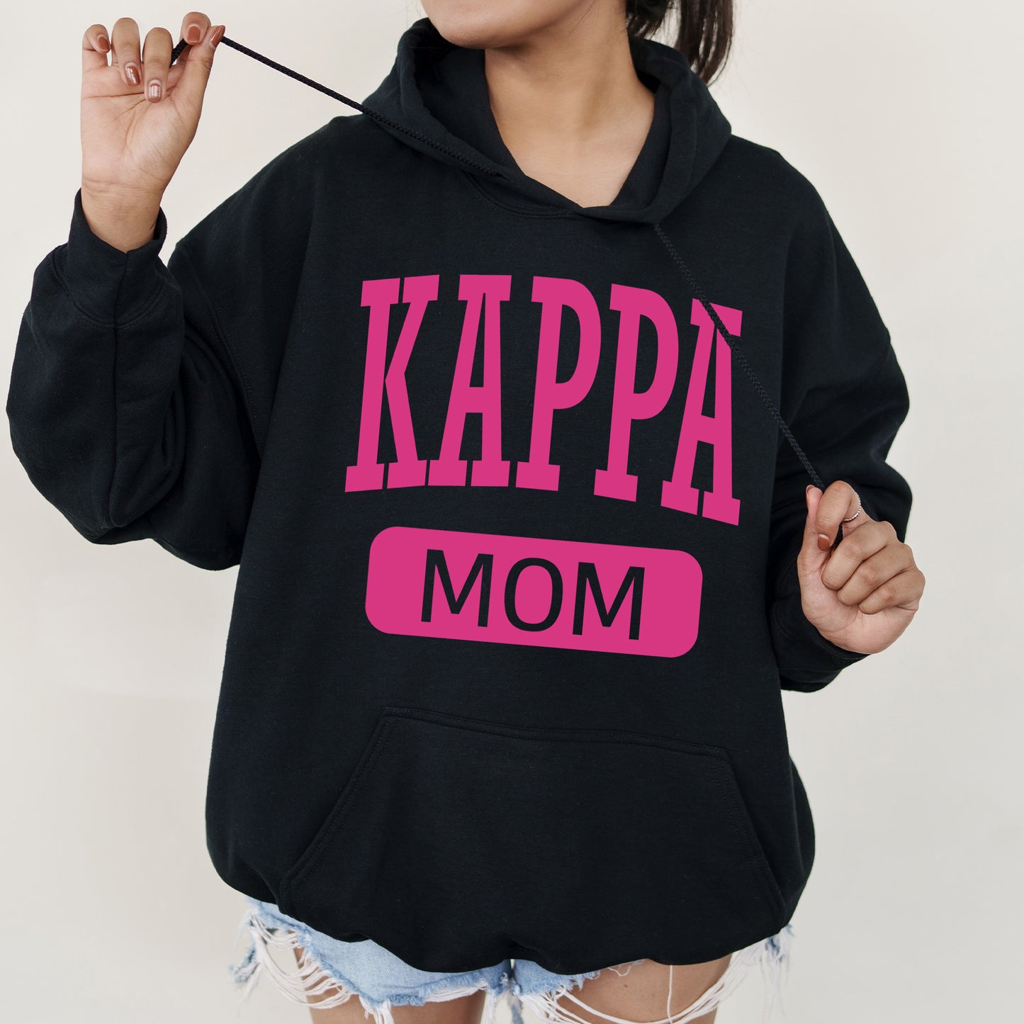 a woman in a black hoodie with pink letters on it
