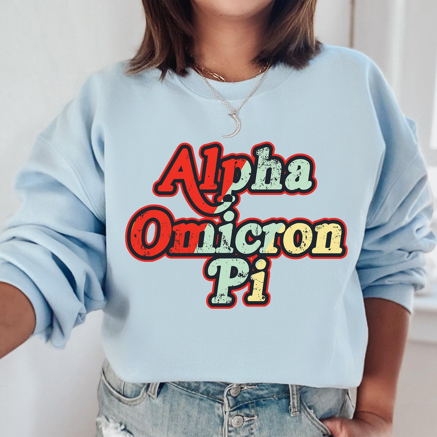a woman wearing a light blue sweatshirt that says aloha omicron pi