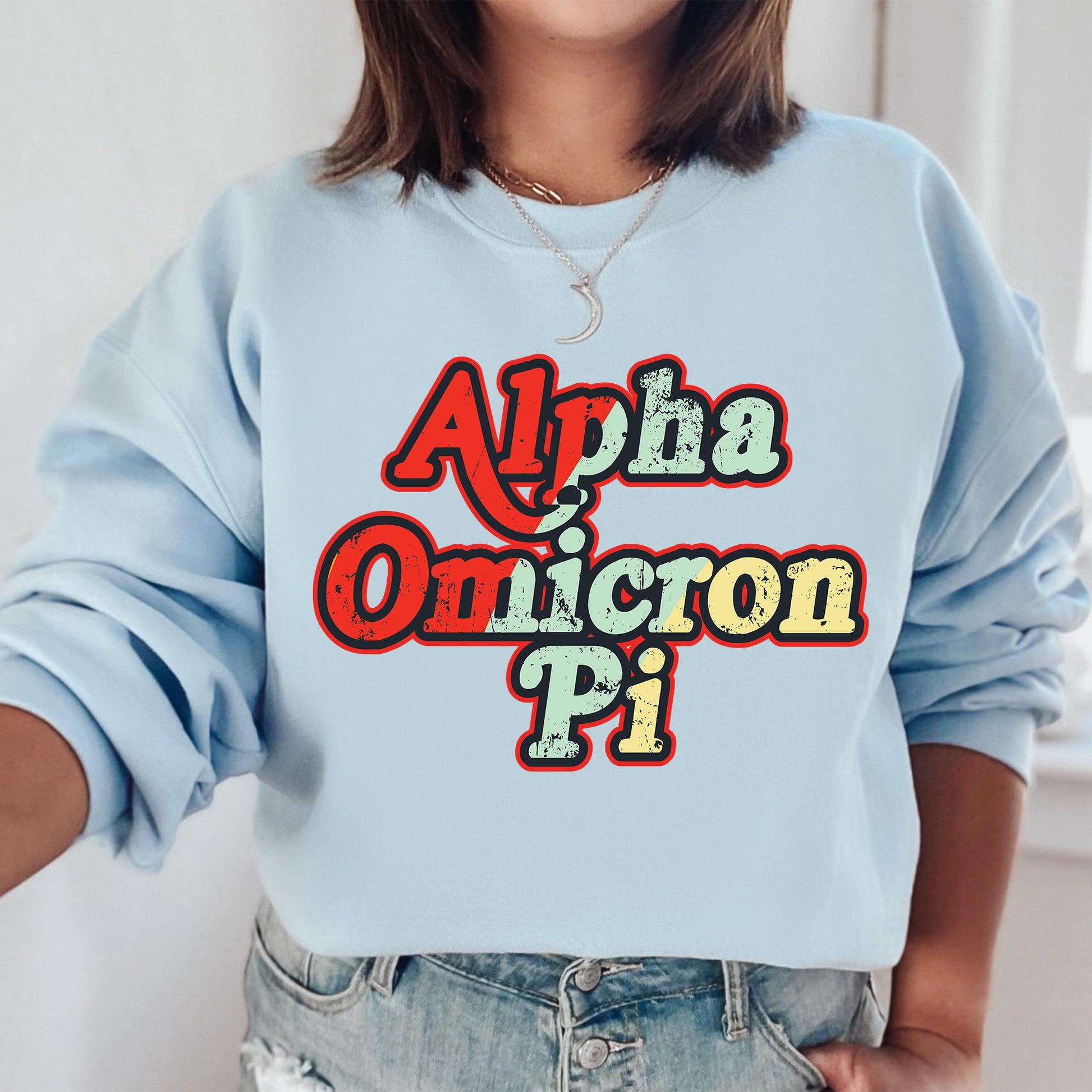 a woman wearing a light blue sweatshirt that says aloha omicron pi
