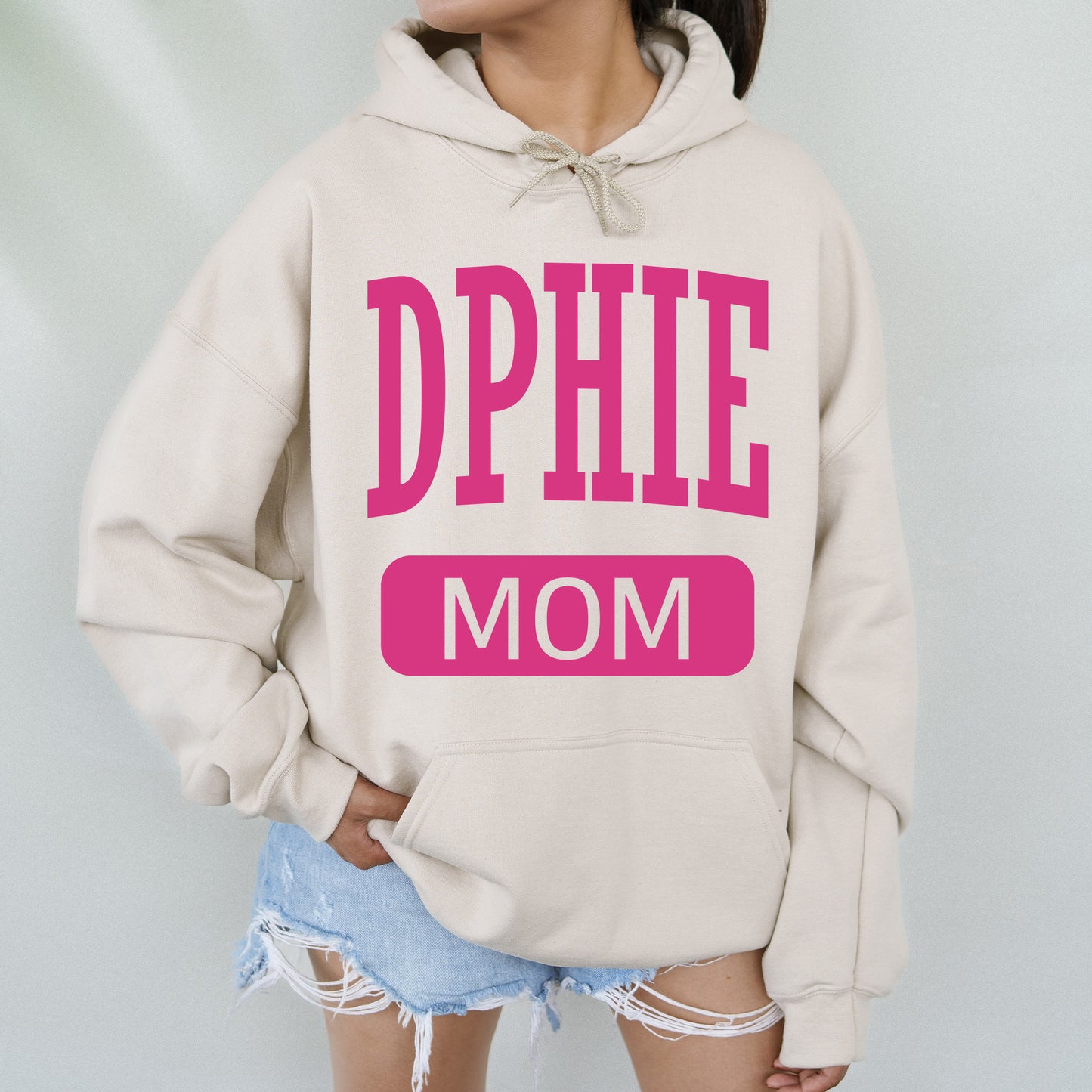 a woman wearing a sweatshirt with the words dppie mom on it